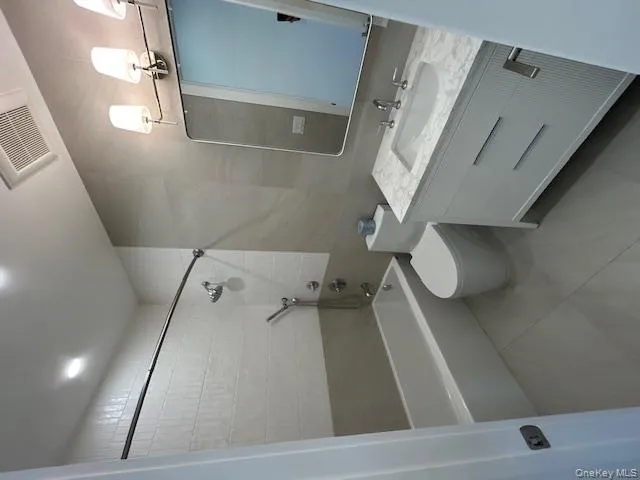 Full bathroom with vanity, shower / tub combination, and light tile patterned floors Full bathroom with vanity, shower / tub combination, and light tile patterned floors