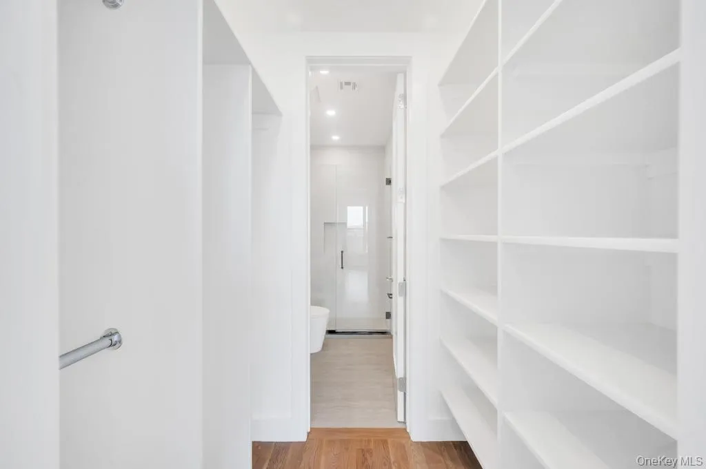 Walk in closet featuring light wood-style floors Walk in closet featuring light wood-style floors