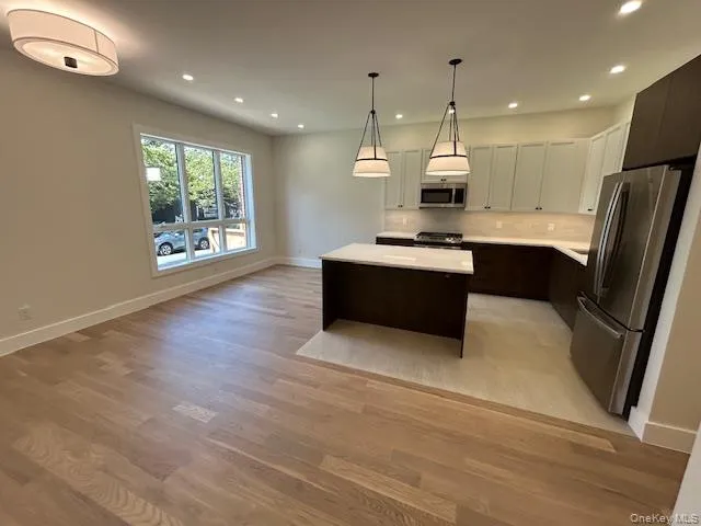 Kitchen with stainless steel appliances, a kitchen island, recessed lighting, dark brown cabinetry, and decorative backsplash Kitchen with stainless steel appliances, a kitchen island, recessed lighting, dark brown cabinetry, and decorative backsplash
