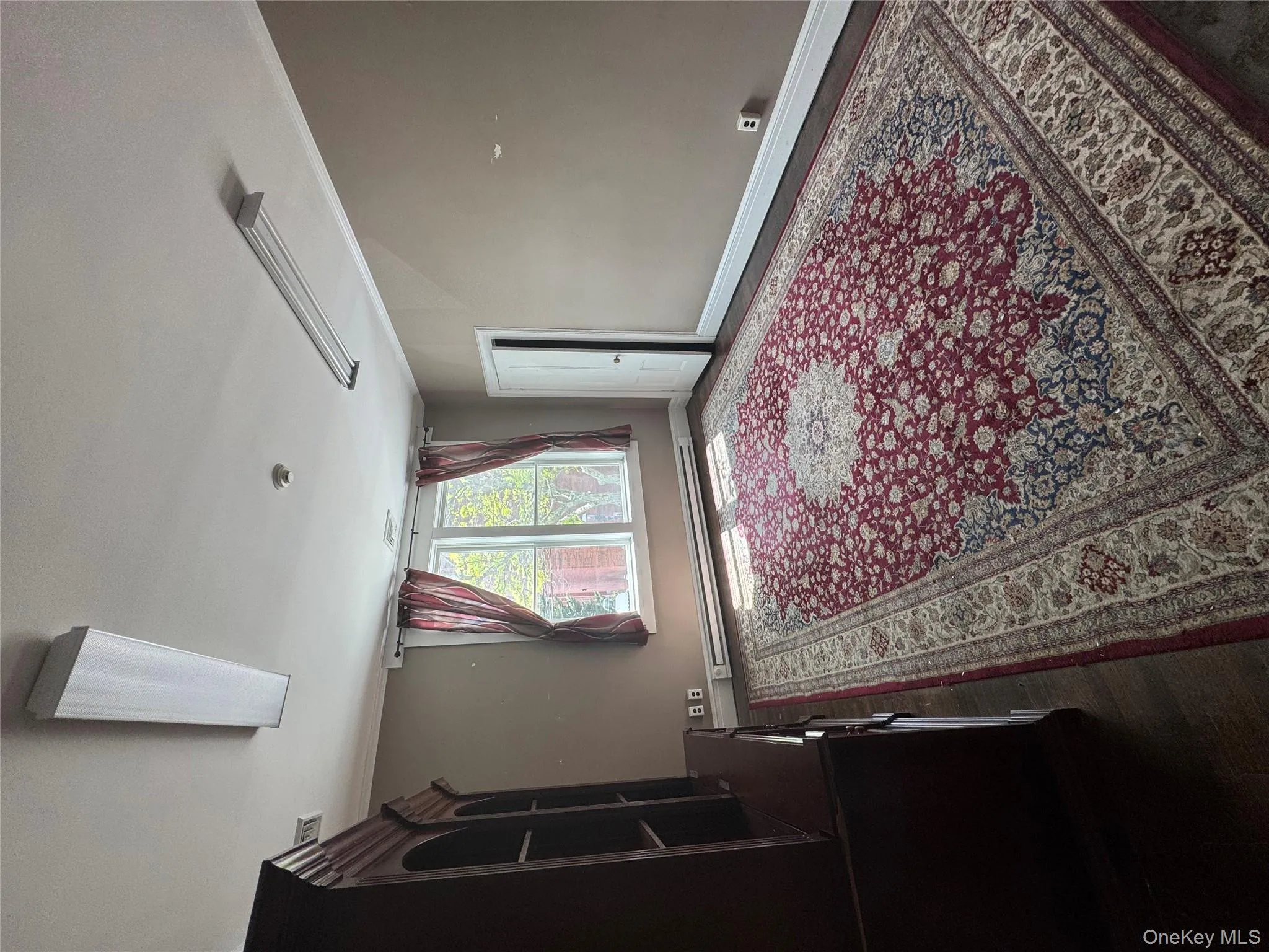Bedroom featuring ornamental molding, dark wood-type flooring, and a baseboard heating unit Bedroom featuring ornamental molding, dark wood-type flooring, and a baseboard heating unit