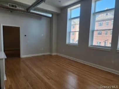 Unfurnished room with wood finished floors and baseboards Unfurnished room with wood finished floors and baseboards