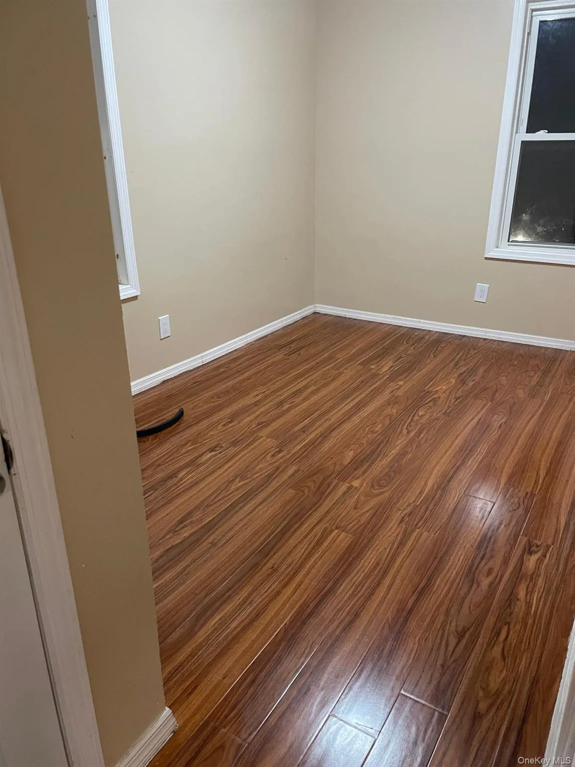 Spare room featuring dark wood-style floors Spare room featuring dark wood-style floors