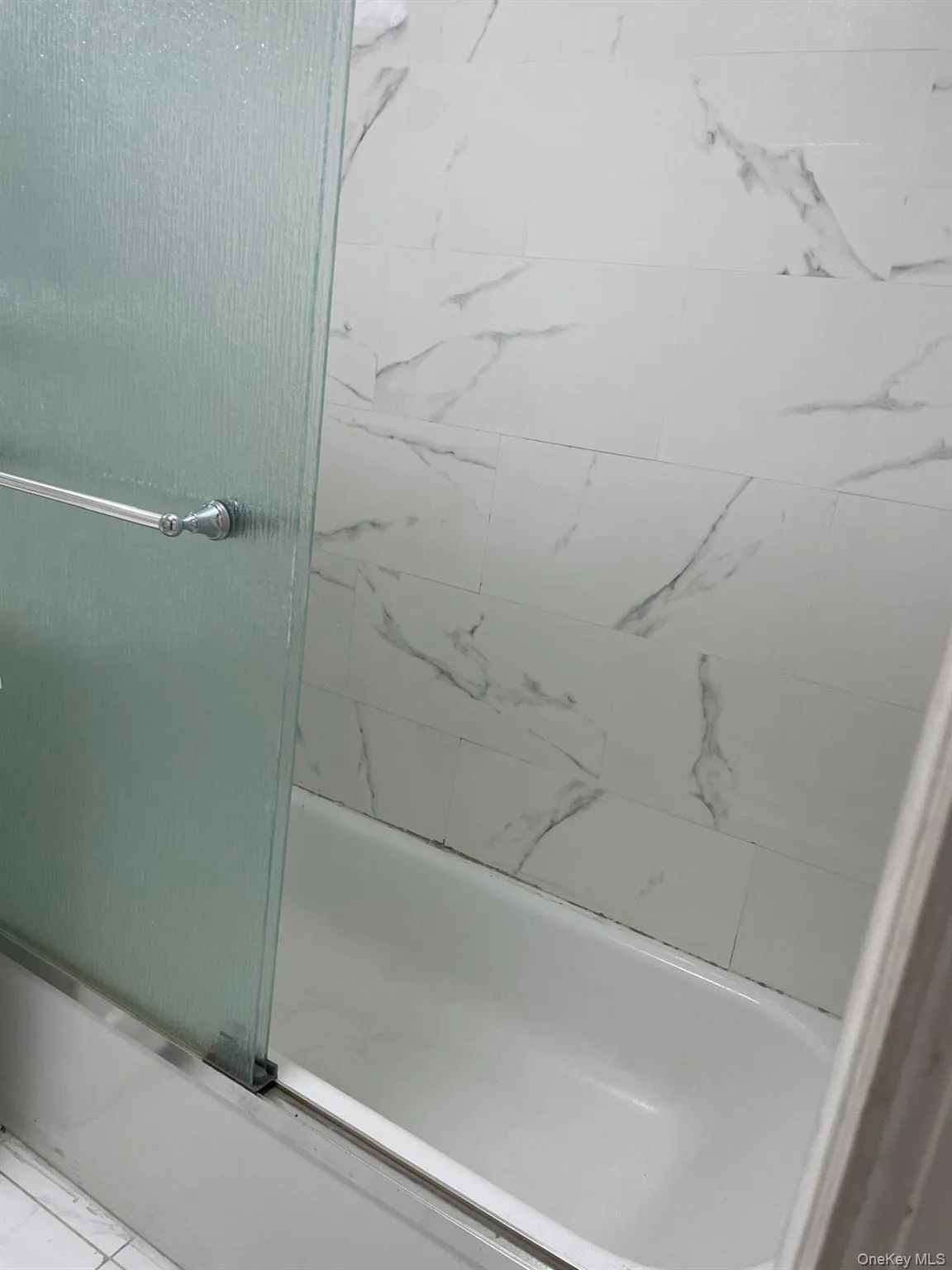 Full bathroom featuring bath / shower combo with glass door Full bathroom featuring bath / shower combo with glass door