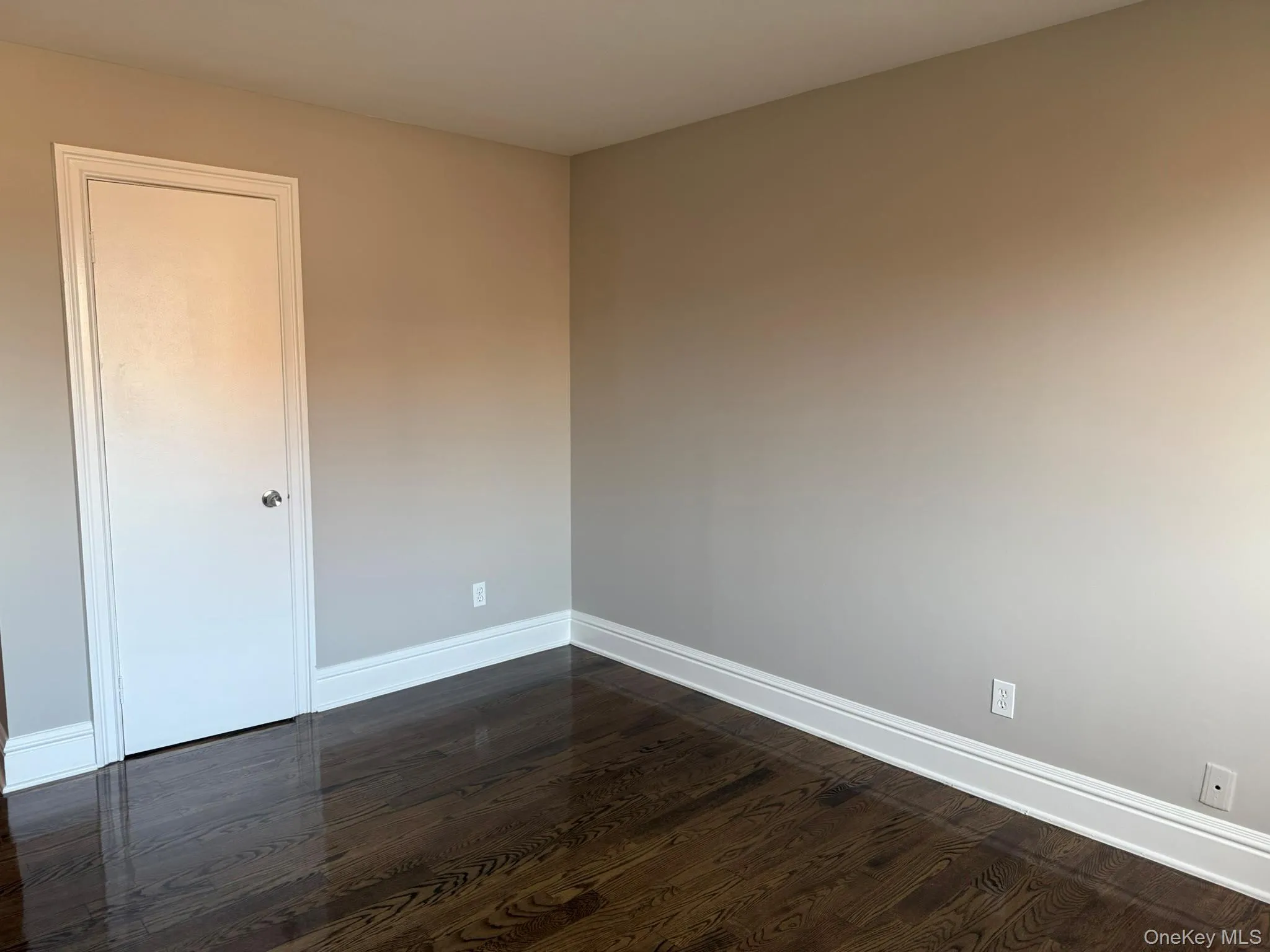 Spare room featuring baseboards and dark wood finished floors Spare room featuring baseboards and dark wood finished floors