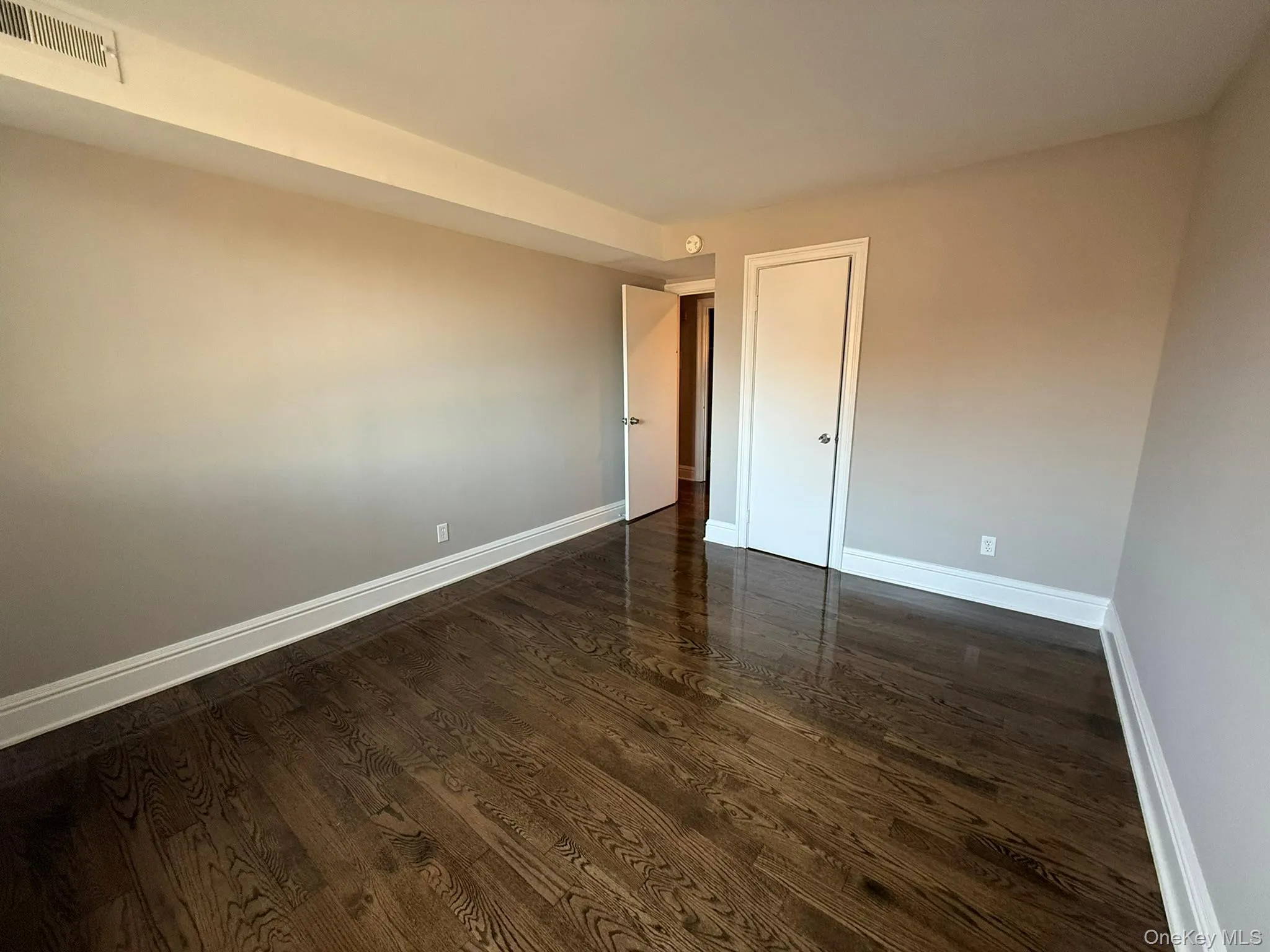 Unfurnished room featuring dark wood-type flooring Unfurnished room featuring dark wood-type flooring