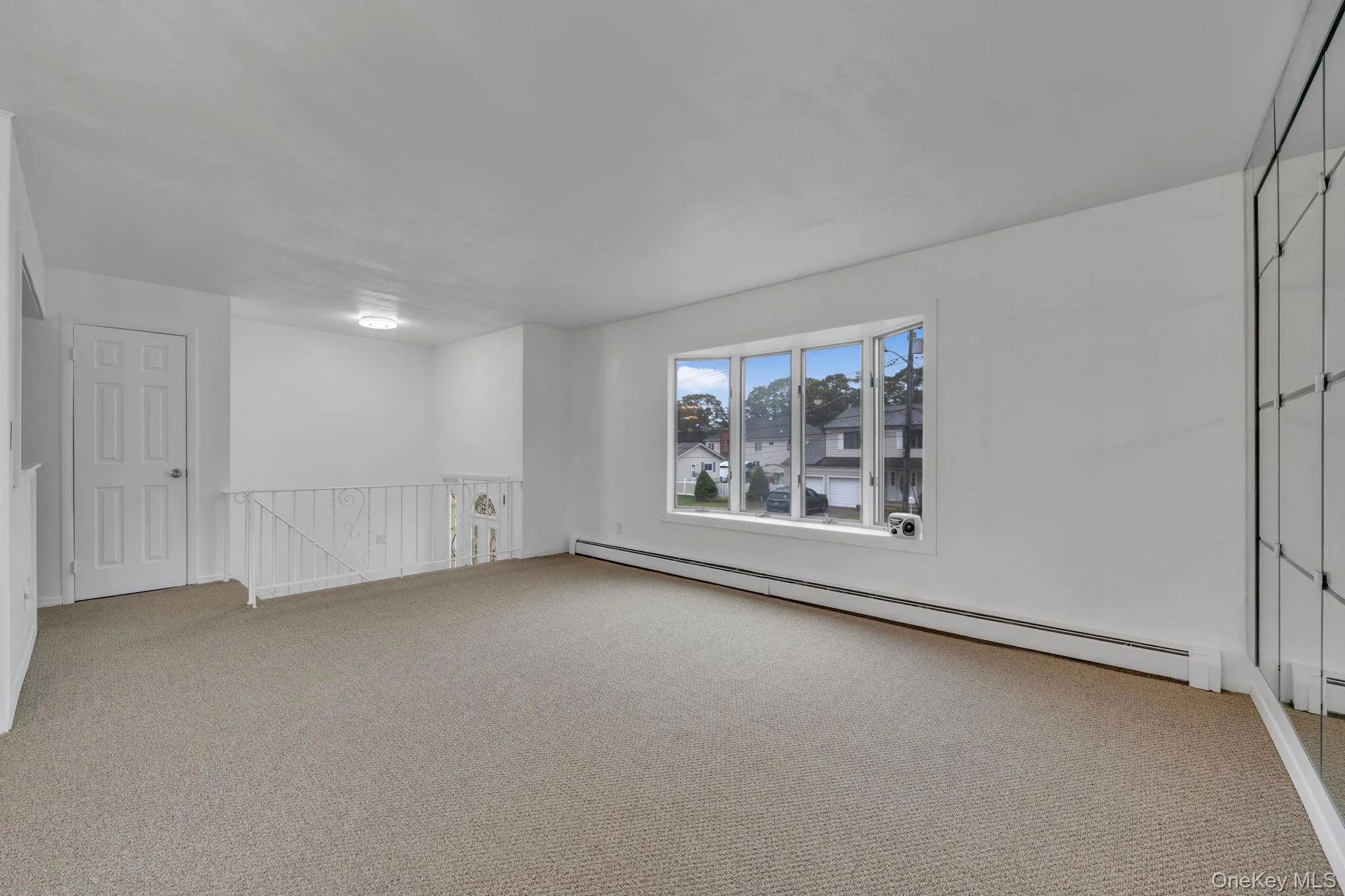 Unfurnished room featuring baseboard heating and carpet floors Unfurnished room featuring baseboard heating and carpet floors