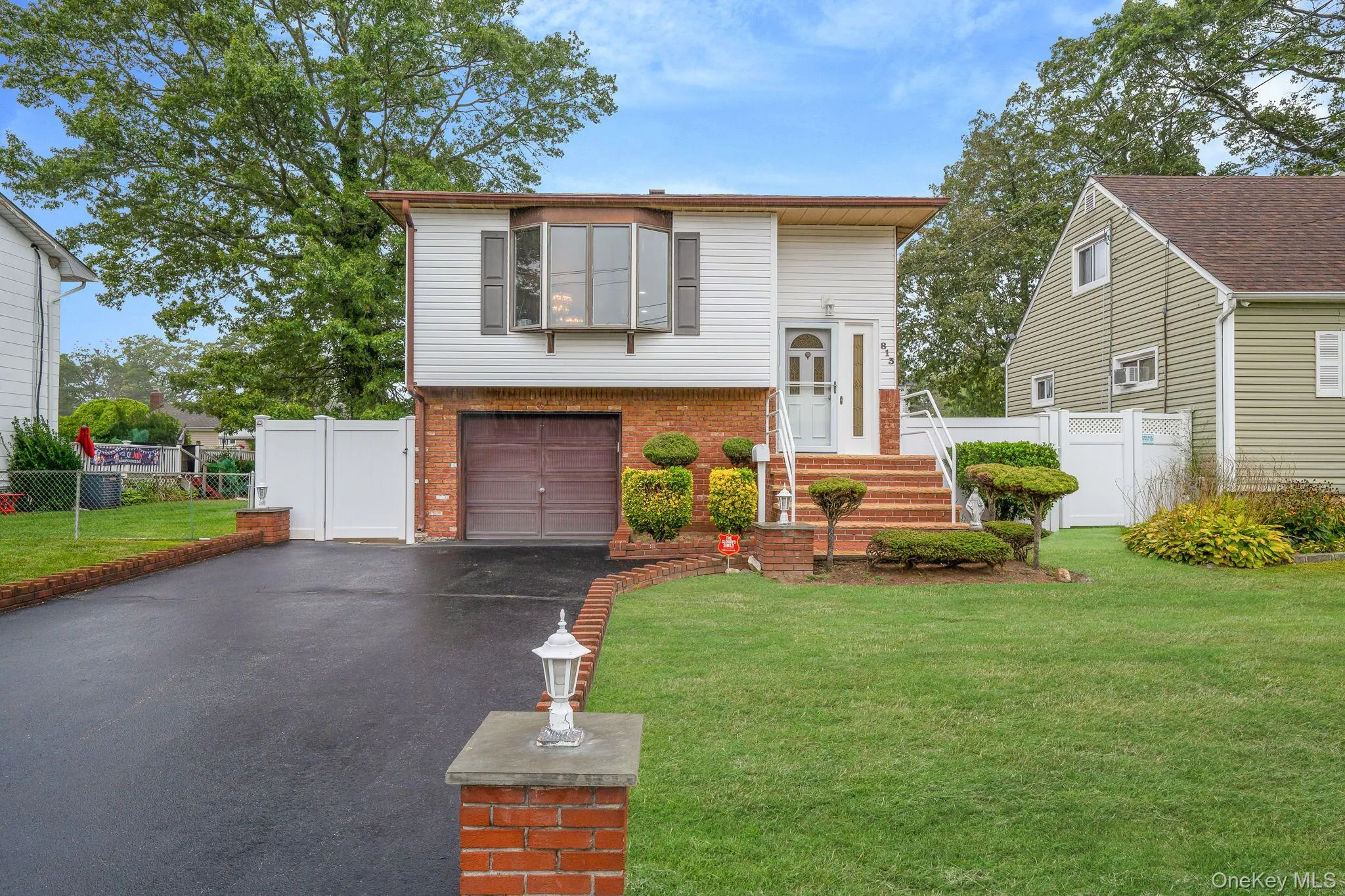 View of front of home with brick siding, asphalt driveway, a gate, and a garage View of front of home with brick siding, asphalt driveway, a gate, and a garage