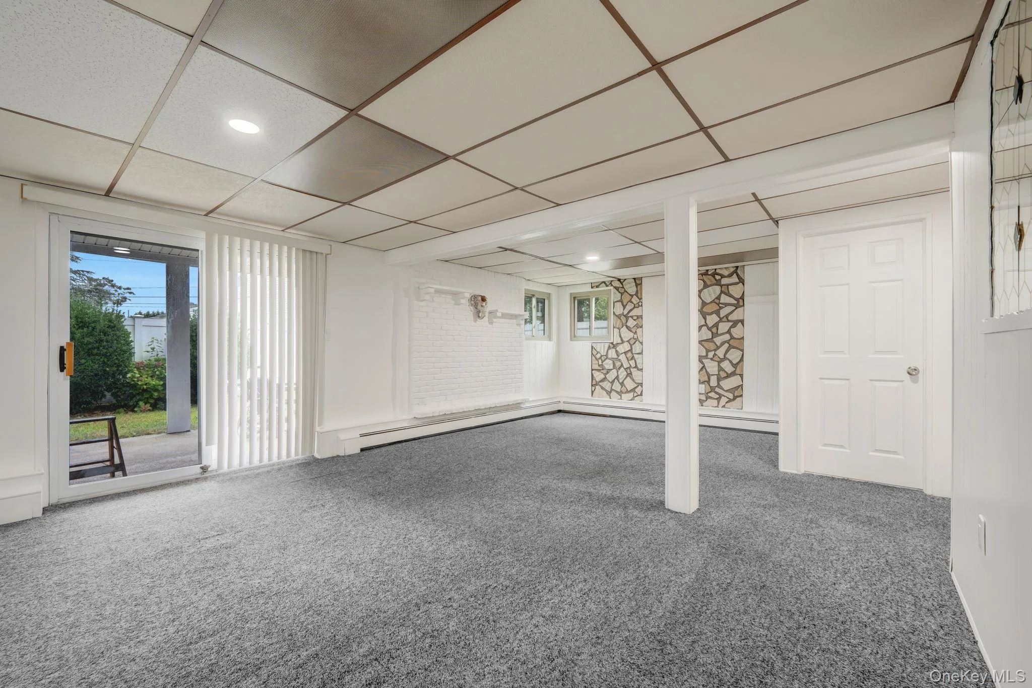 Basement with carpet and a paneled ceiling Basement with carpet and a paneled ceiling