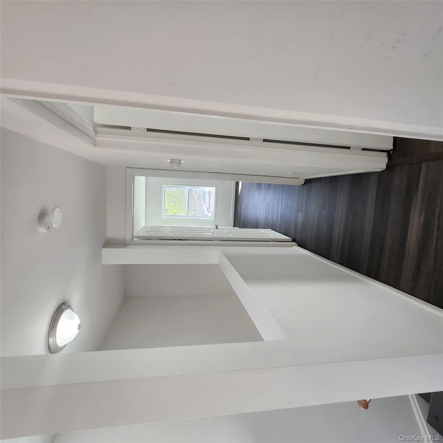 Hall with dark wood-type flooring and baseboards Hall with dark wood-type flooring and baseboards