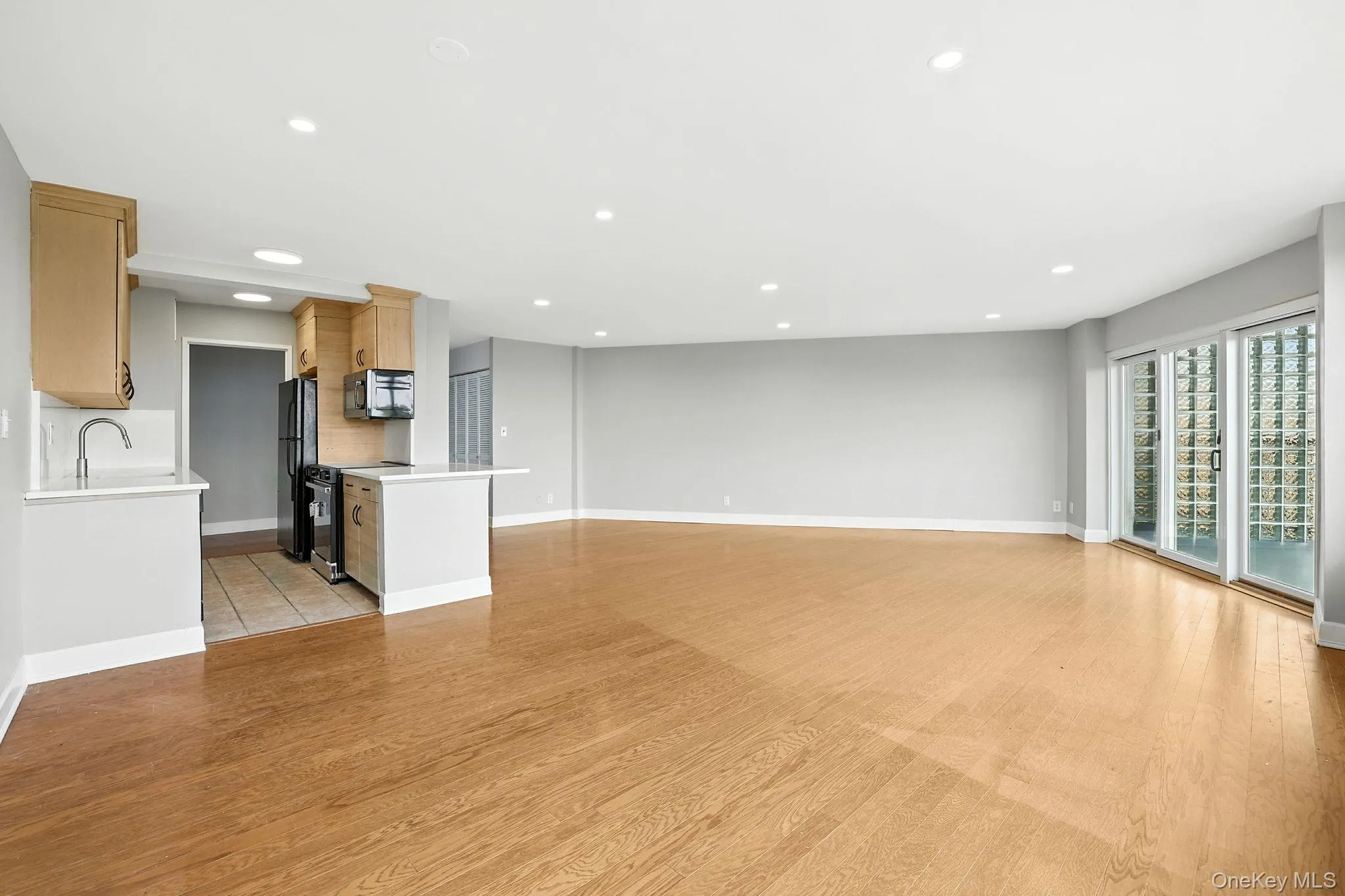 Unfurnished living room with light wood flooring and recessed lighting Unfurnished living room with light wood flooring and recessed lighting