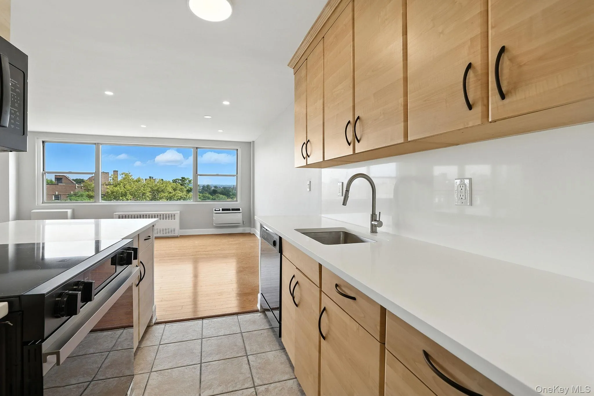Kitchen featuring range with electric stovetop, radiator, light tile patterned floors, brand new quartz countertops, and recessed lighting Kitchen featuring range with electric stovetop, radiator, light tile patterned floors, brand new quartz countertops, and recessed lighting