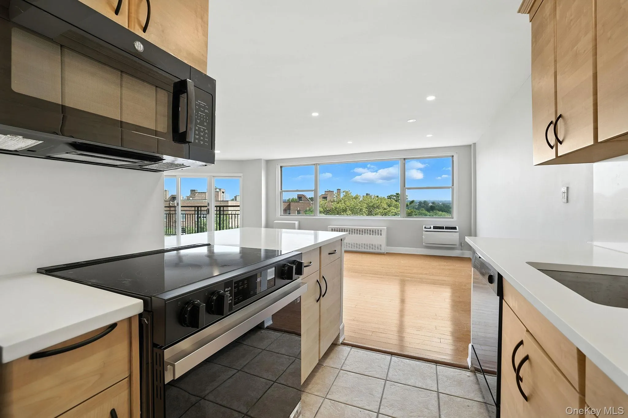 Kitchen featuring electric range oven, black microwave, light tile patterned floors, a fantastic amount of natural light, and recessed lighting Kitchen featuring electric range oven, black microwave, light tile patterned floors, a fantastic amount of natural light, and recessed lighting