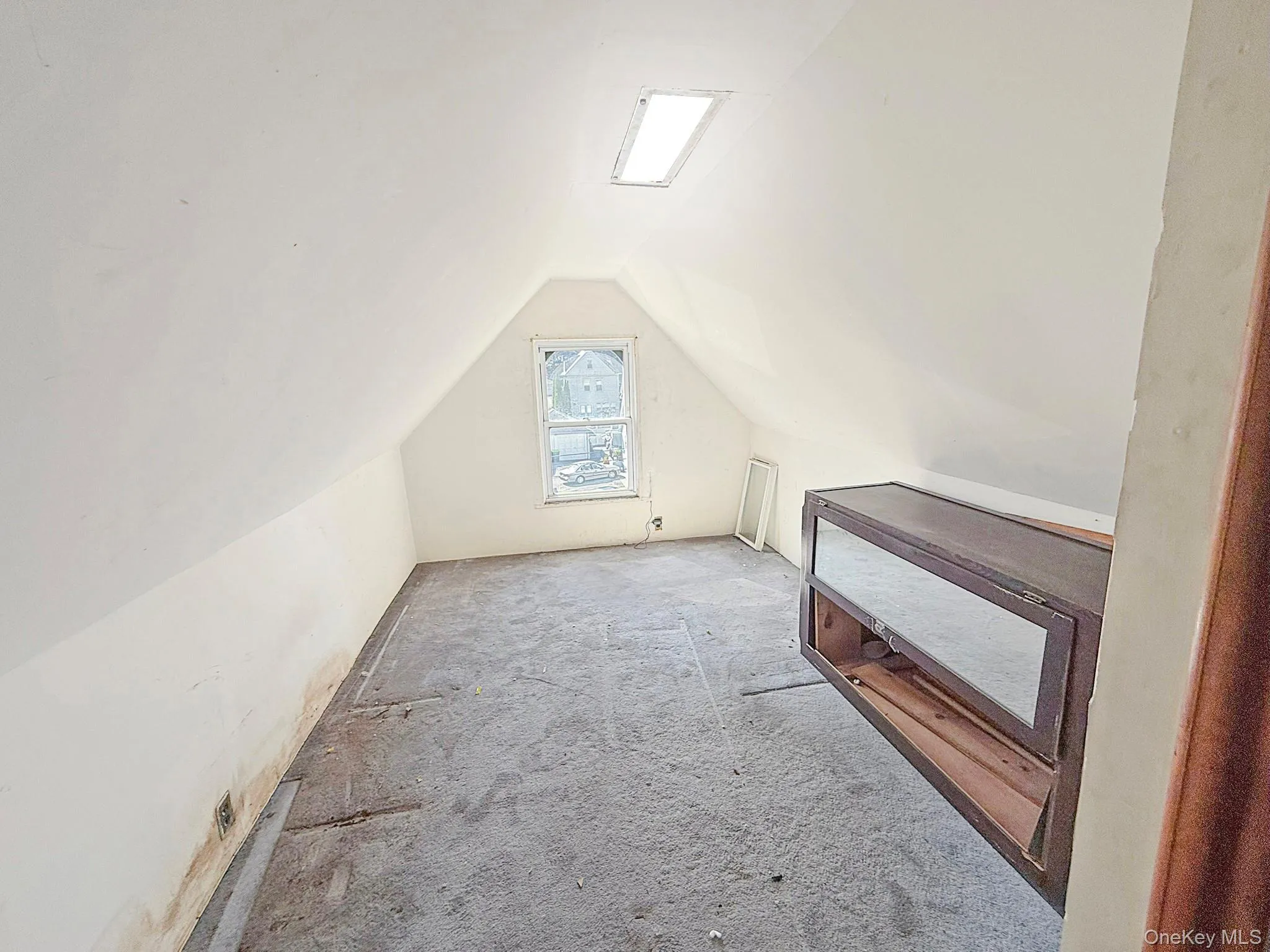 Additional living space featuring vaulted ceiling and carpet flooring Additional living space featuring vaulted ceiling and carpet flooring
