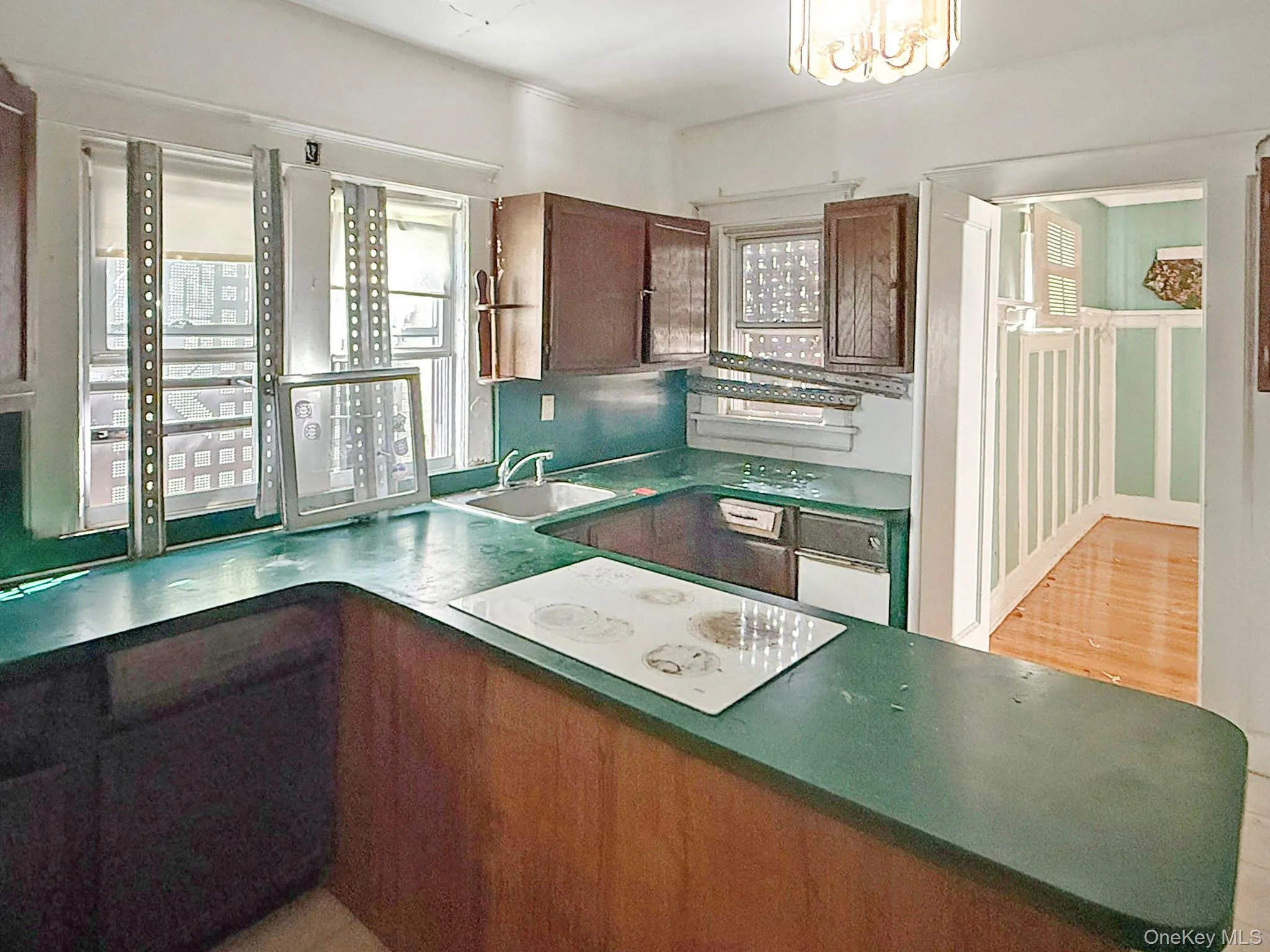 Kitchen with white electric cooktop, plenty of natural light, and dark countertops Kitchen with white electric cooktop, plenty of natural light, and dark countertops