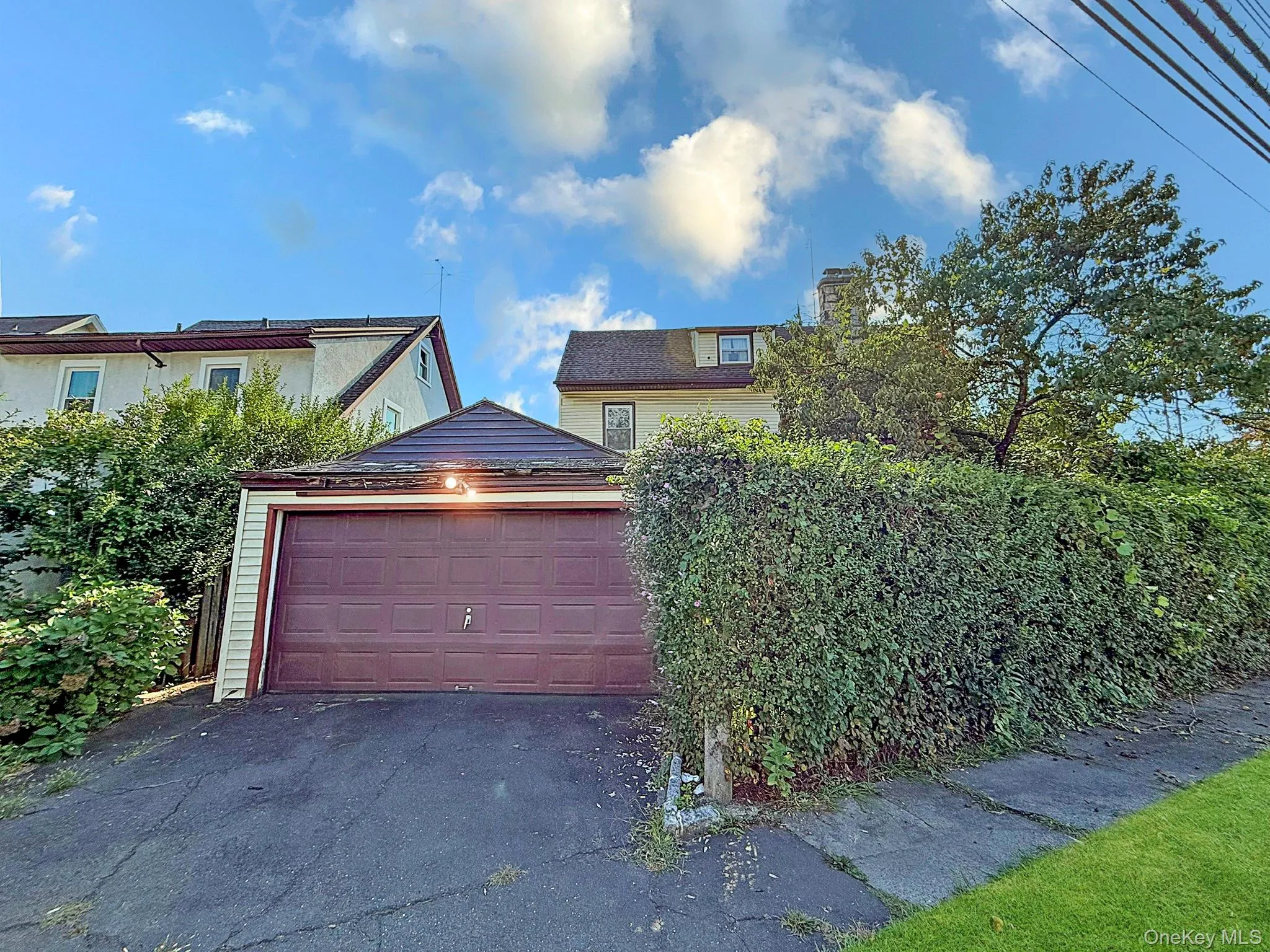 View of front facade featuring a chimney, asphalt driveway, and an attached garage View of front facade featuring a chimney, asphalt driveway, and an attached garage