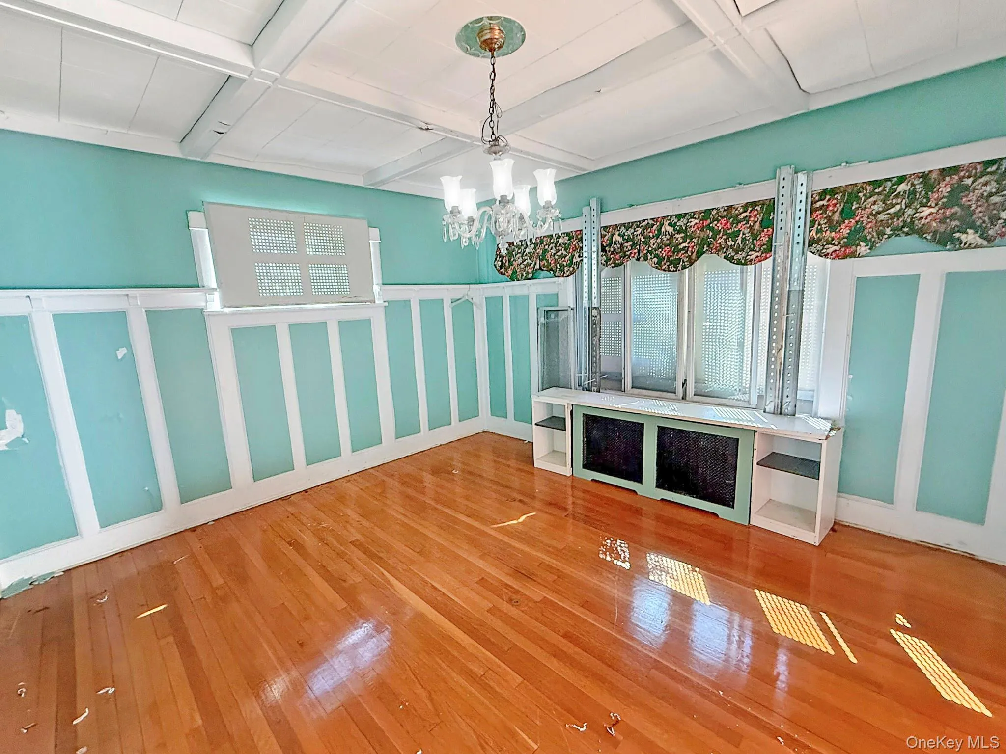 Unfurnished dining area with hardwood / wood-style flooring, a chandelier, beamed ceiling, and coffered ceiling Unfurnished dining area with hardwood / wood-style flooring, a chandelier, beamed ceiling, and coffered ceiling