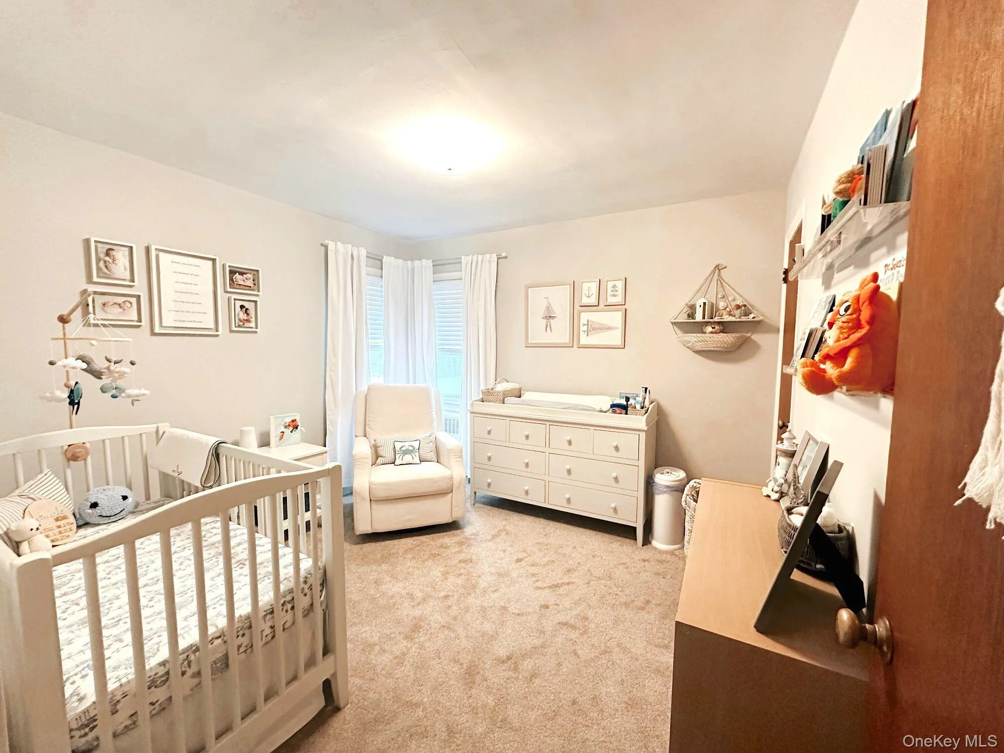 Bedroom featuring light colored carpet and a nursery area Bedroom featuring light colored carpet and a nursery area