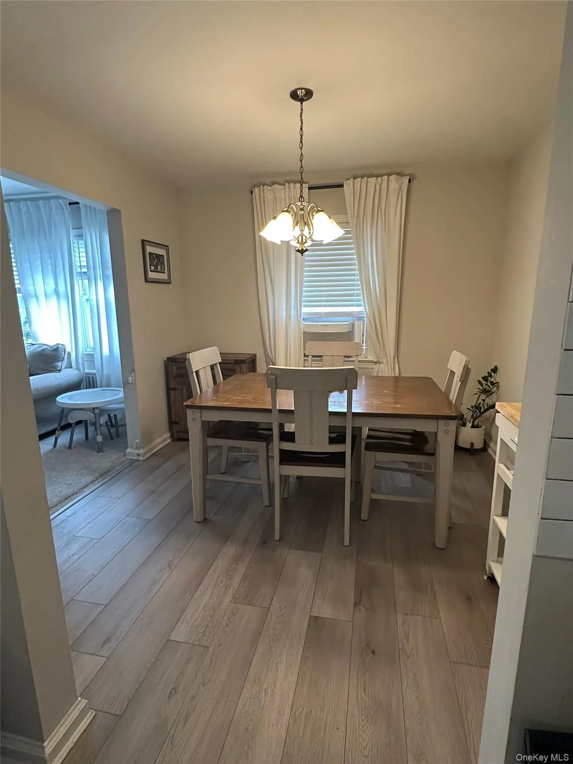 Dining room featuring light wood-style flooring, plenty of natural light, and a chandelier Dining room featuring light wood-style flooring, plenty of natural light, and a chandelier