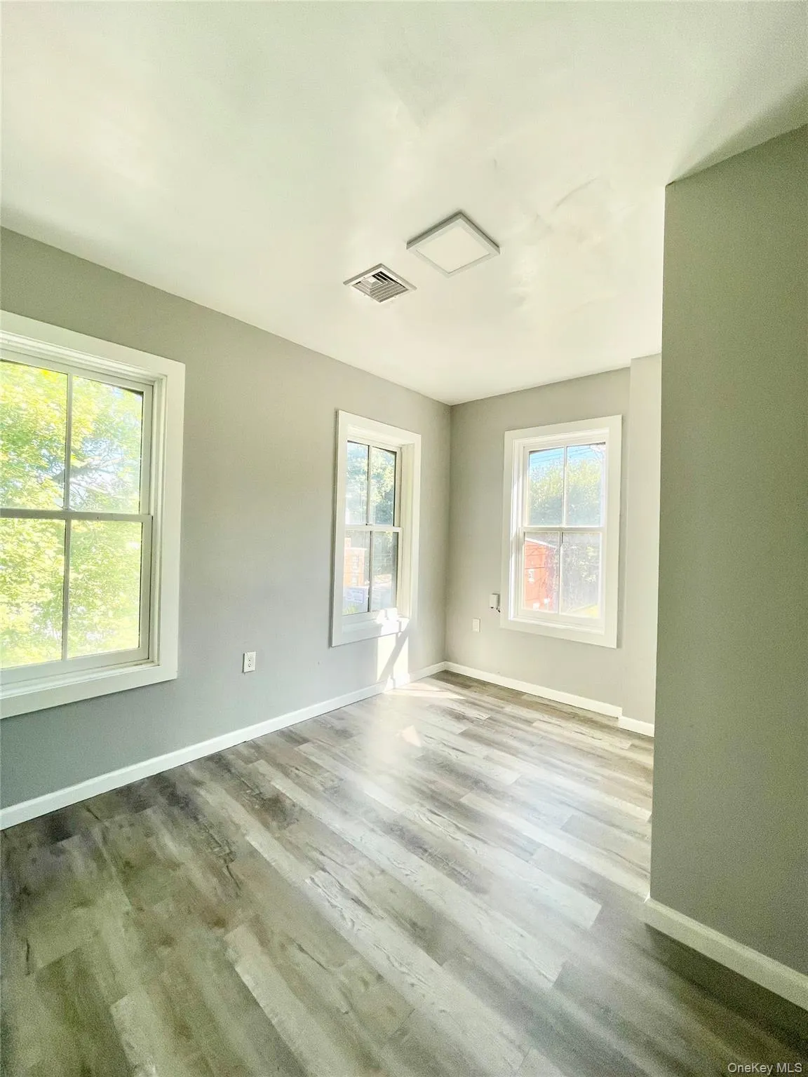 Unfurnished room with baseboards and wood finished floors Unfurnished room with baseboards and wood finished floors