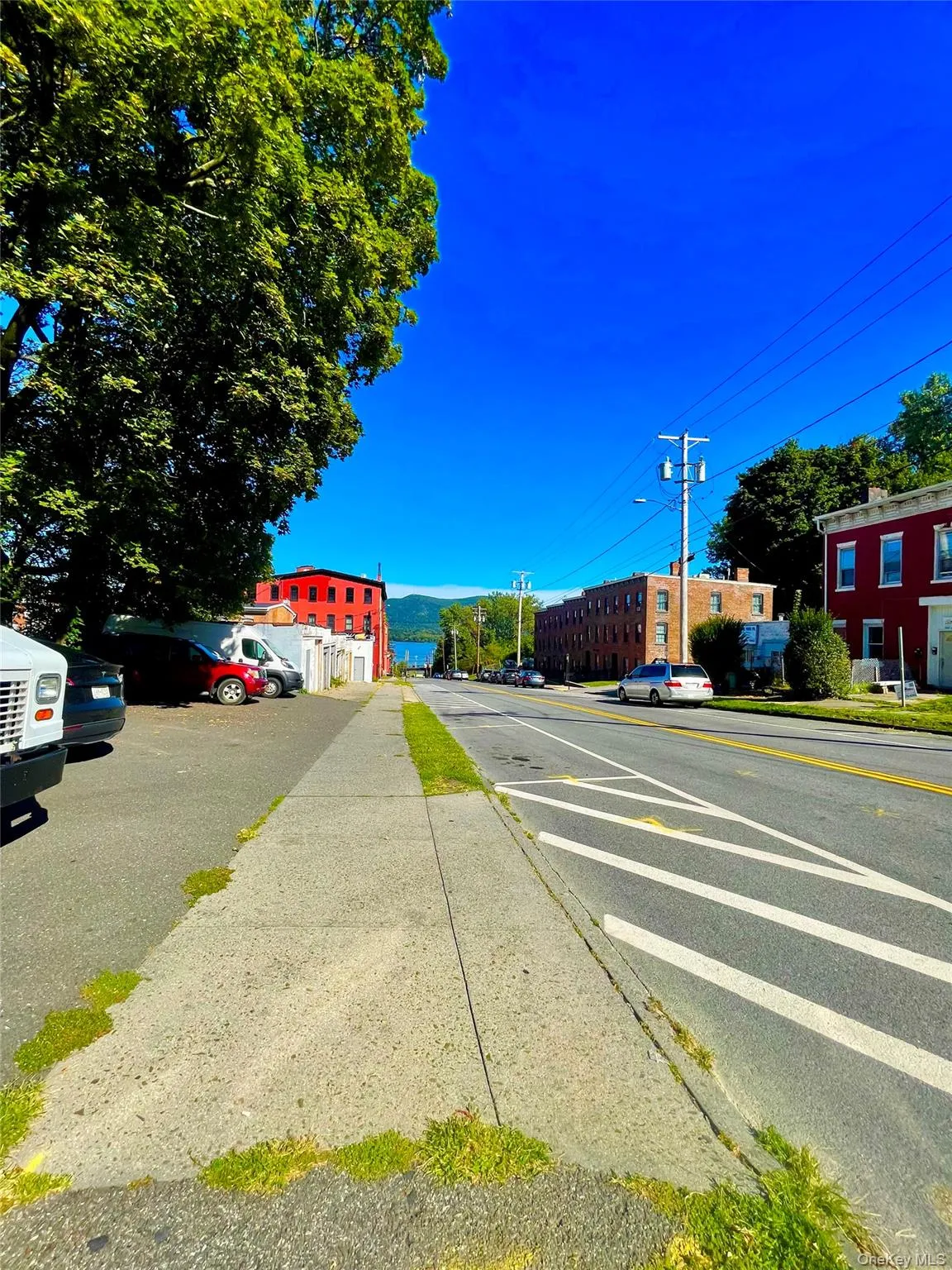 View of asphalt street featuring sidewalks, street lighting, and curbs View of asphalt street featuring sidewalks, street lighting, and curbs