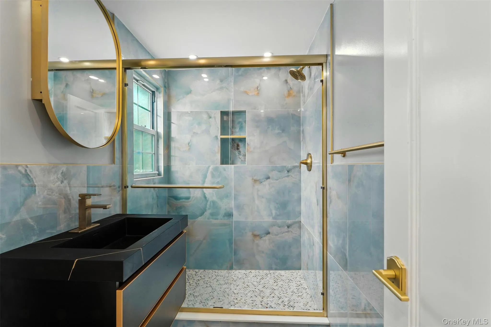 Bathroom featuring a shower stall, vanity, and tile walls Bathroom featuring a shower stall, vanity, and tile walls