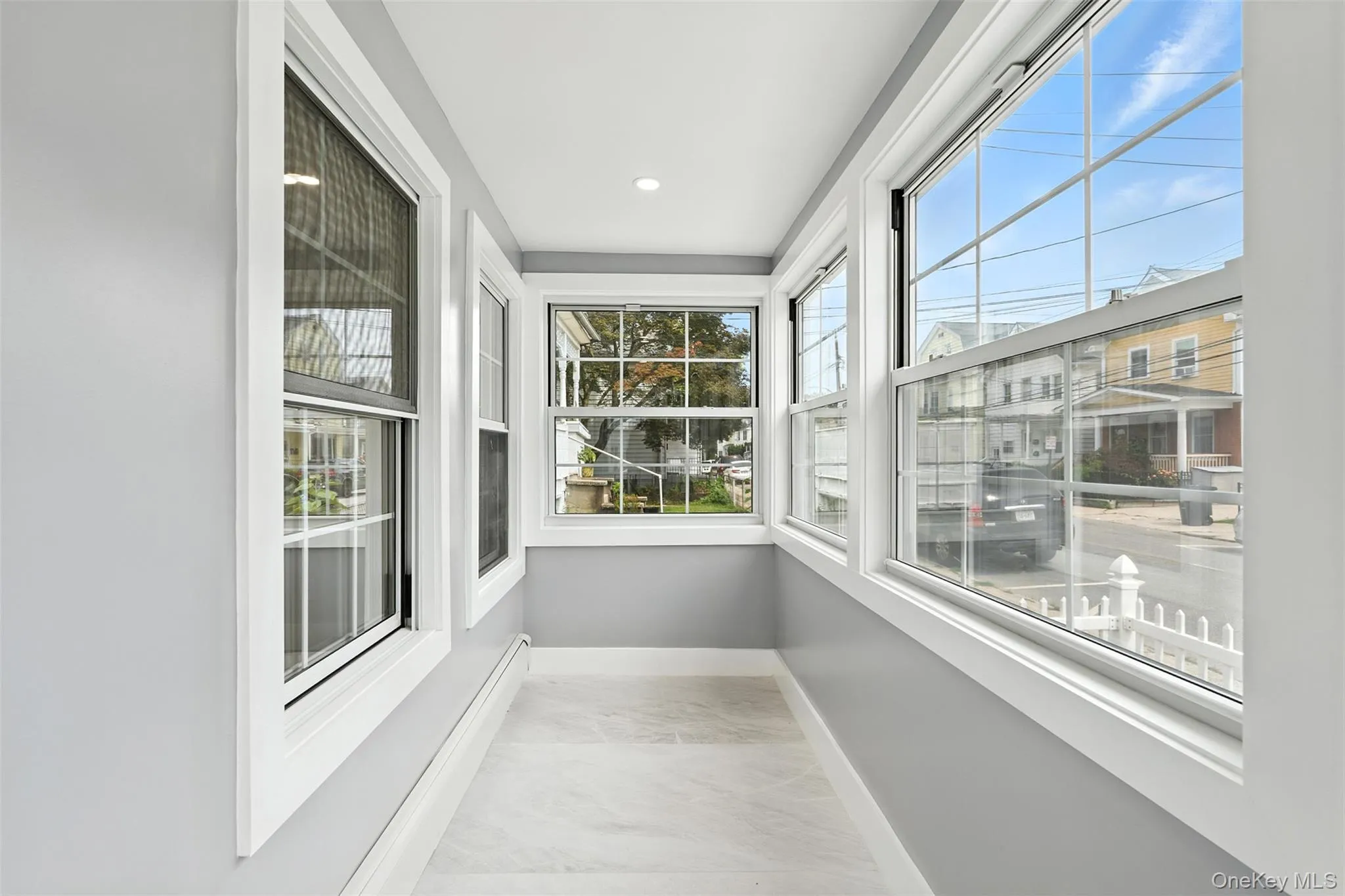Unfurnished sunroom with marble look tile flooring and recessed lighting Unfurnished sunroom with marble look tile flooring and recessed lighting