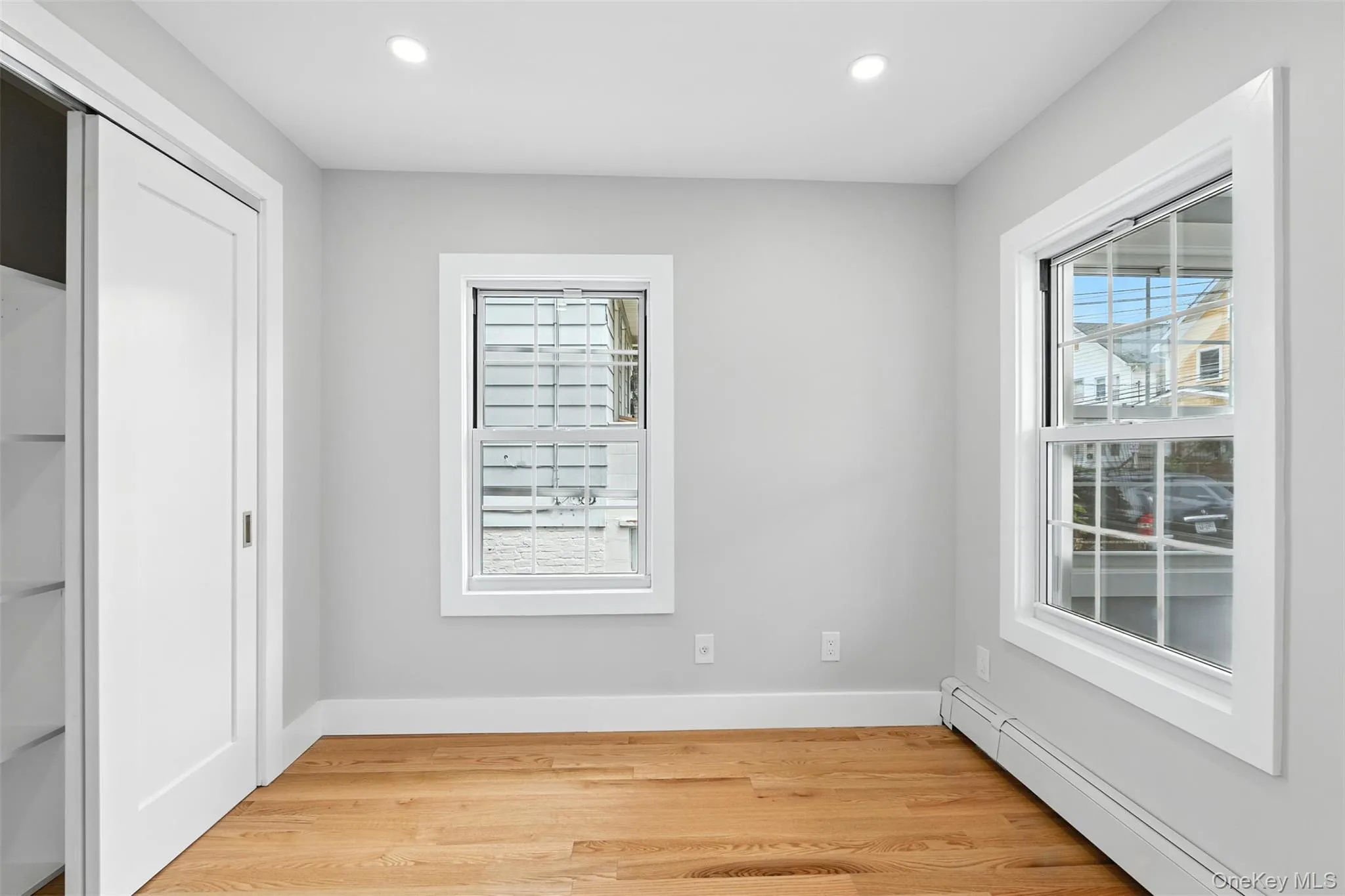 Unfurnished bedroom with a baseboard heating unit, light wood-style floors, and recessed lighting Unfurnished bedroom with a baseboard heating unit, light wood-style floors, and recessed lighting