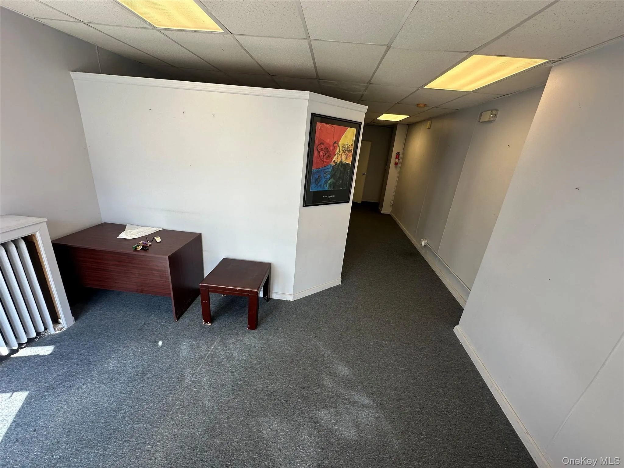 Hall with carpet flooring and a drop ceiling Hall with carpet flooring and a drop ceiling