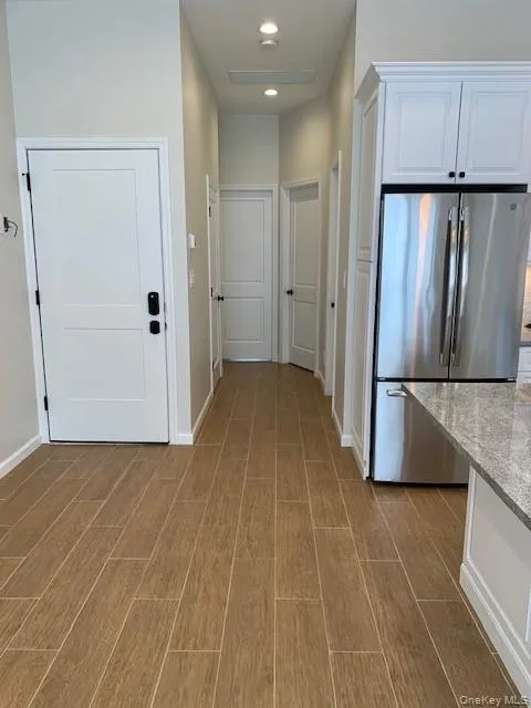 Hall featuring light wood-type flooring and recessed lighting Hall featuring light wood-type flooring and recessed lighting