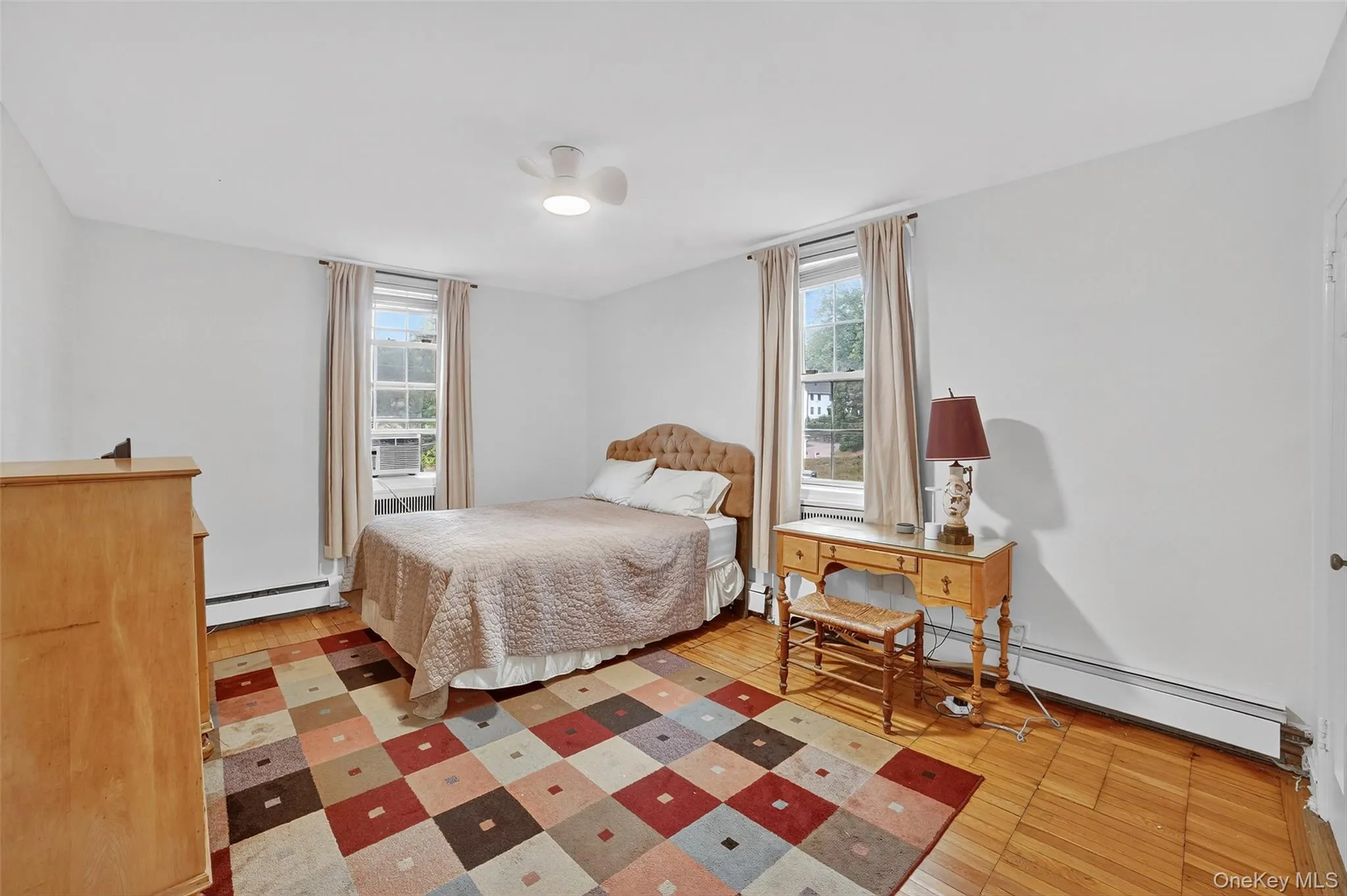 Bedroom with light wood-type flooring and baseboard heating Bedroom with light wood-type flooring and baseboard heating