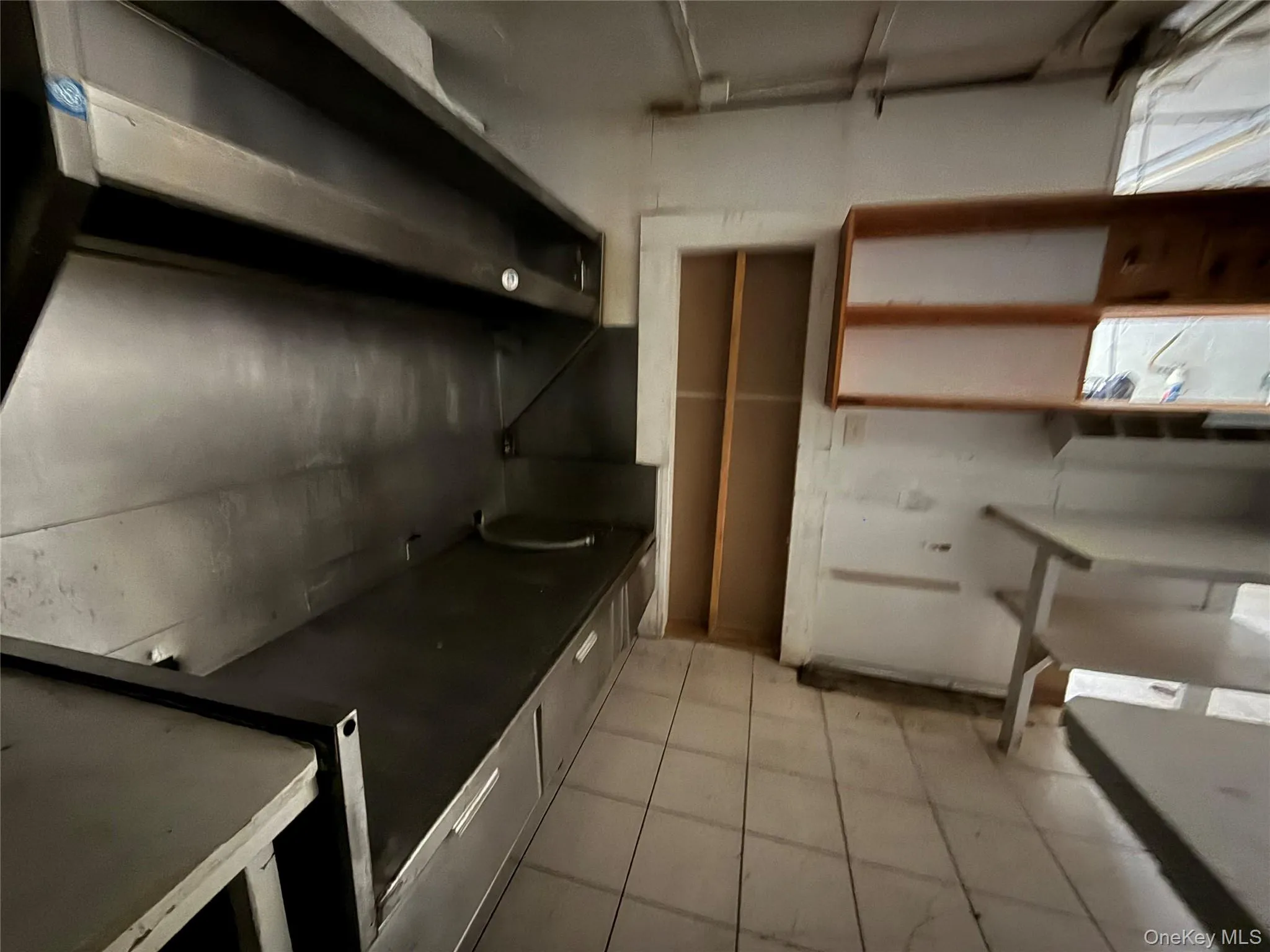 Kitchen with dark countertops and wall chimney exhaust hood Kitchen with dark countertops and wall chimney exhaust hood
