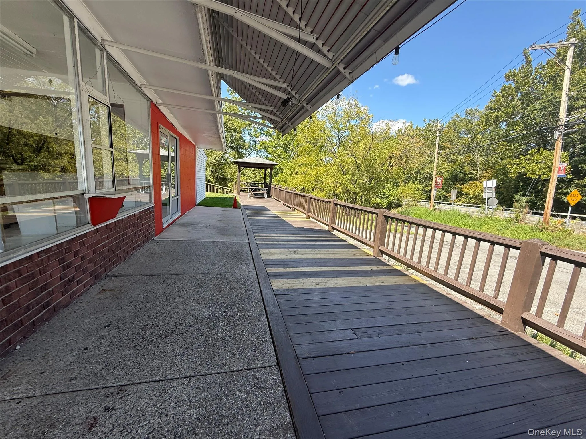Wooden deck with a gazebo and view of scattered trees Wooden deck with a gazebo and view of scattered trees