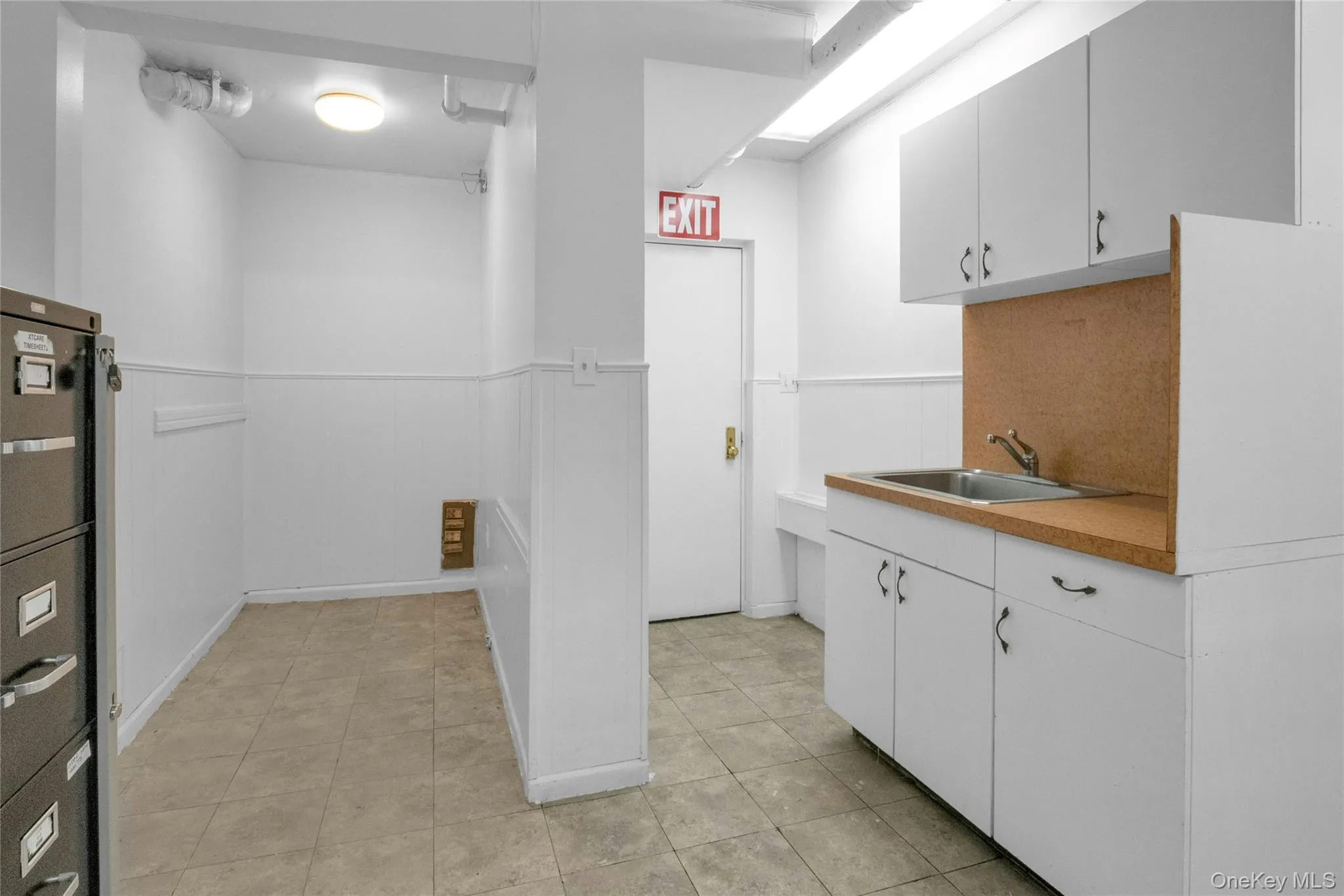 Washroom with a wainscoted wall and light tile patterned floors Washroom with a wainscoted wall and light tile patterned floors