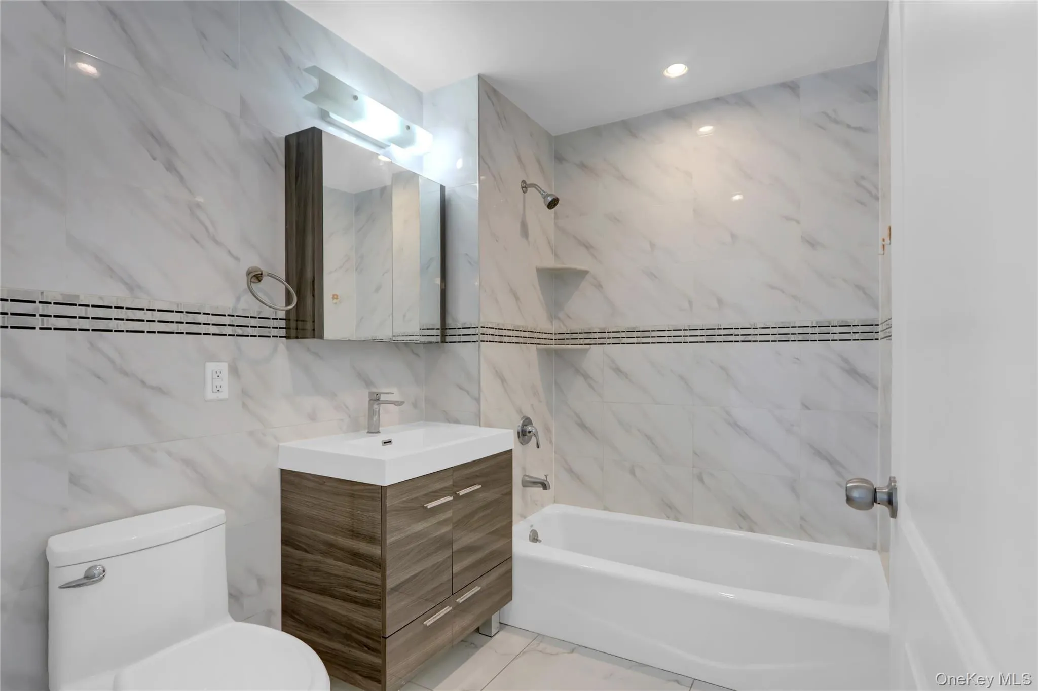 Full bathroom with tile walls, bathing tub / shower combination, and vanity Full bathroom with tile walls, bathing tub / shower combination, and vanity