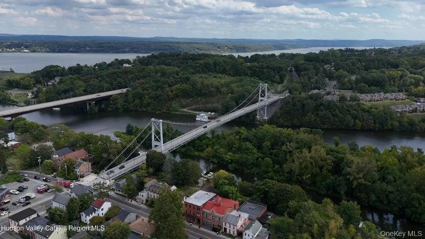 Aerial view of property and surrounding area with a large body of water and a notable bridge Aerial view of property and surrounding area with a large body of water and a notable bridge