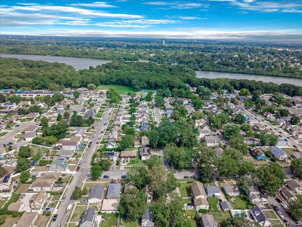 Aerial overview of property's location featuring a nearby body of water and nearby suburban area Aerial overview of property's location featuring a nearby body of water and nearby suburban area
