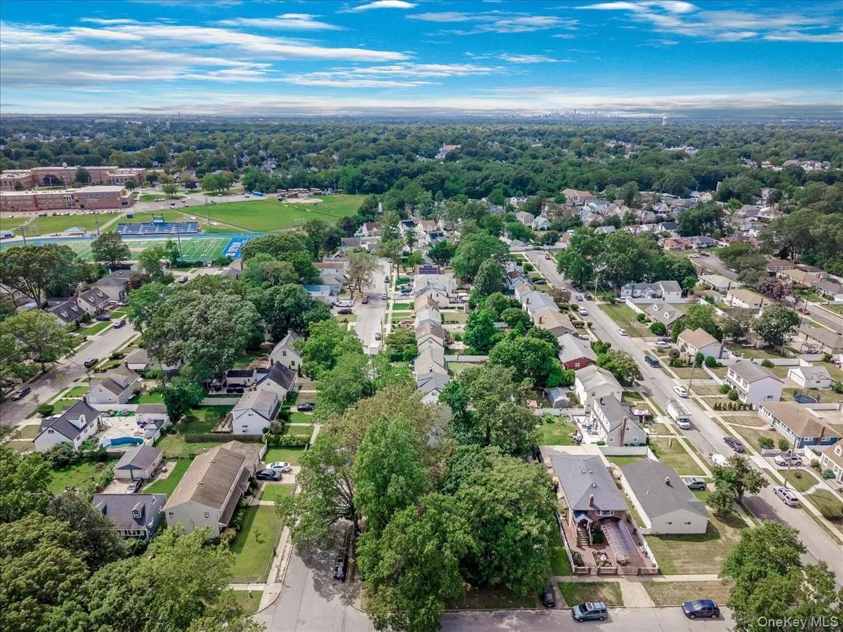 Aerial overview of property's location with nearby suburban area and a tree filled landscape Aerial overview of property's location with nearby suburban area and a tree filled landscape
