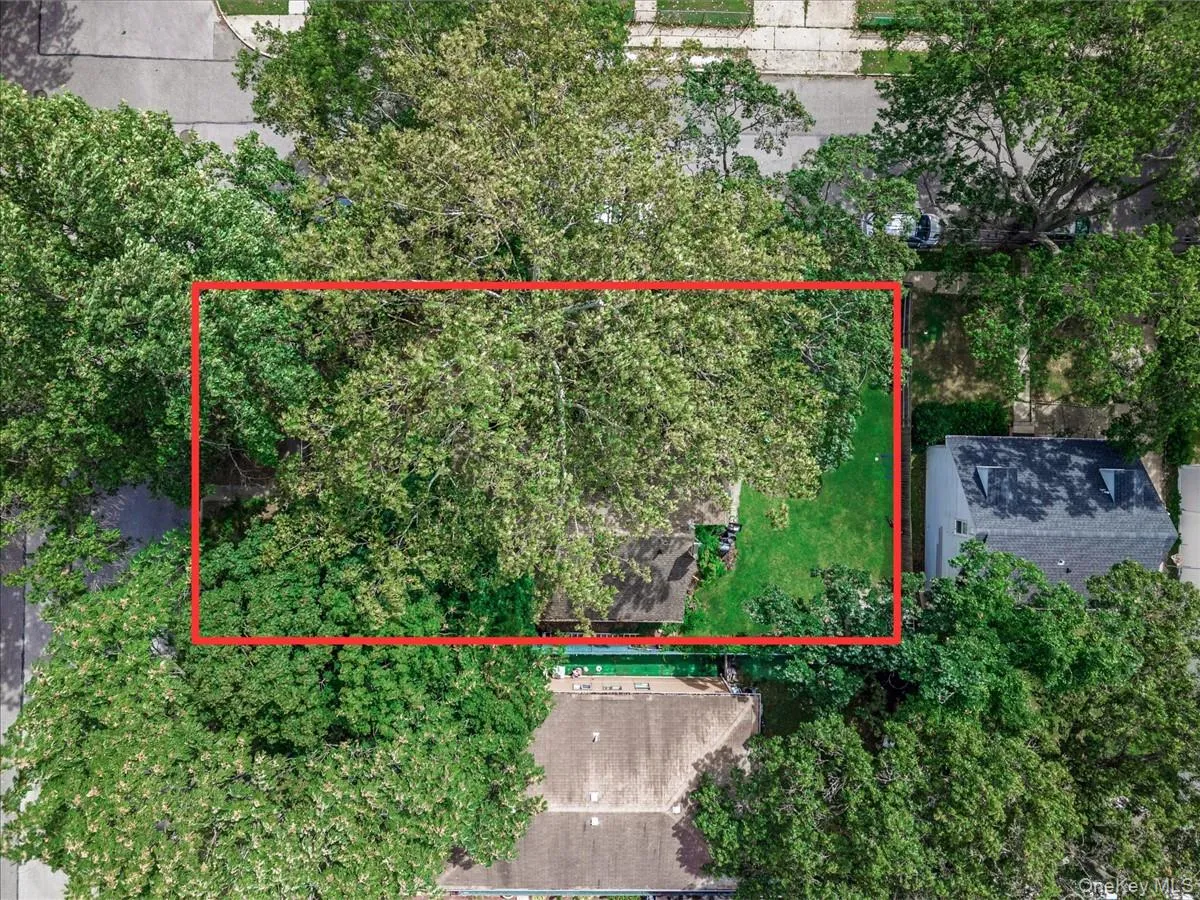 Aerial view of property and surrounding area with property boundaries highlighted and a tree filled landscape Aerial view of property and surrounding area with property boundaries highlighted and a tree filled landscape