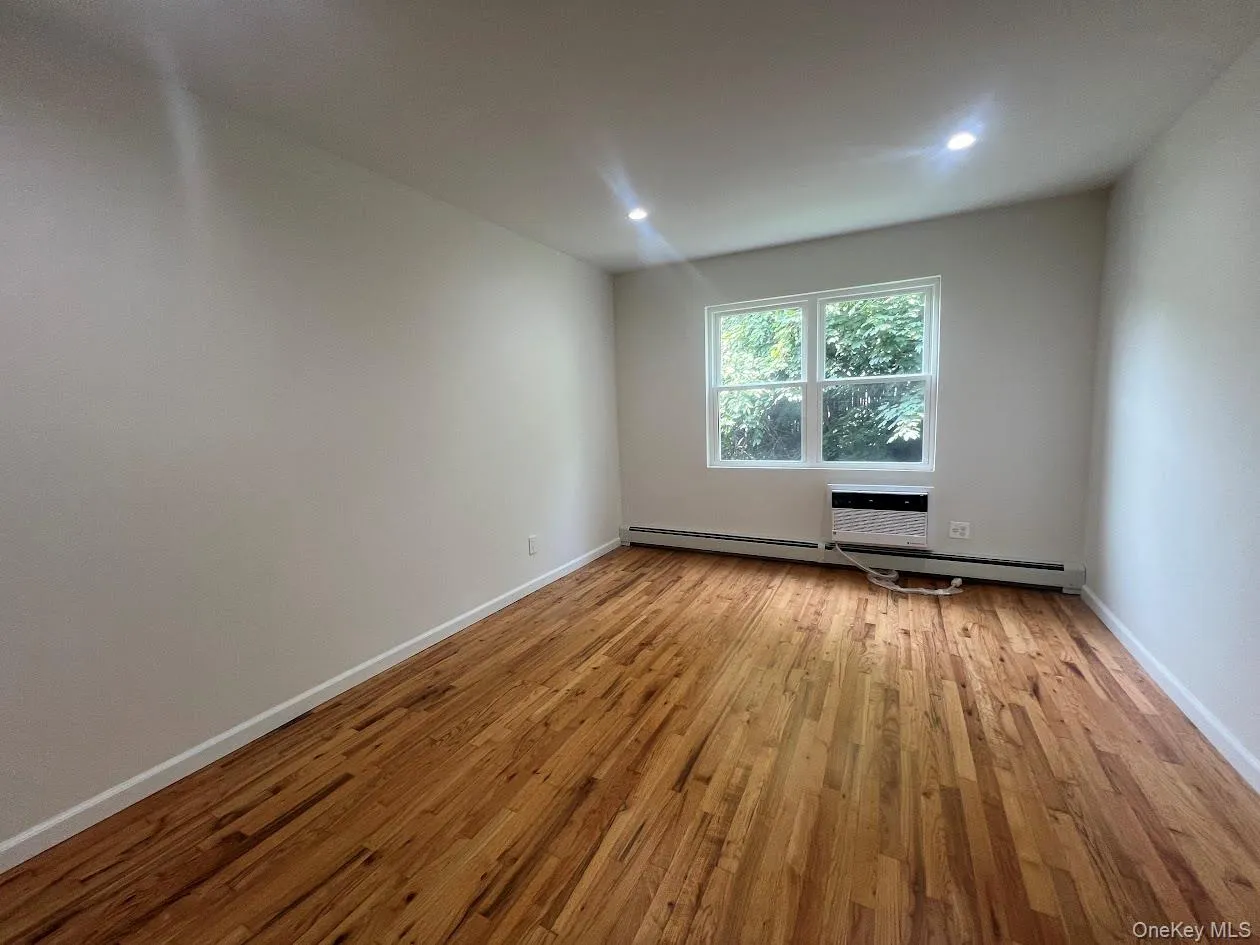 Unfurnished room with light wood-type flooring, a baseboard heating unit, and recessed lighting Unfurnished room with light wood-type flooring, a baseboard heating unit, and recessed lighting