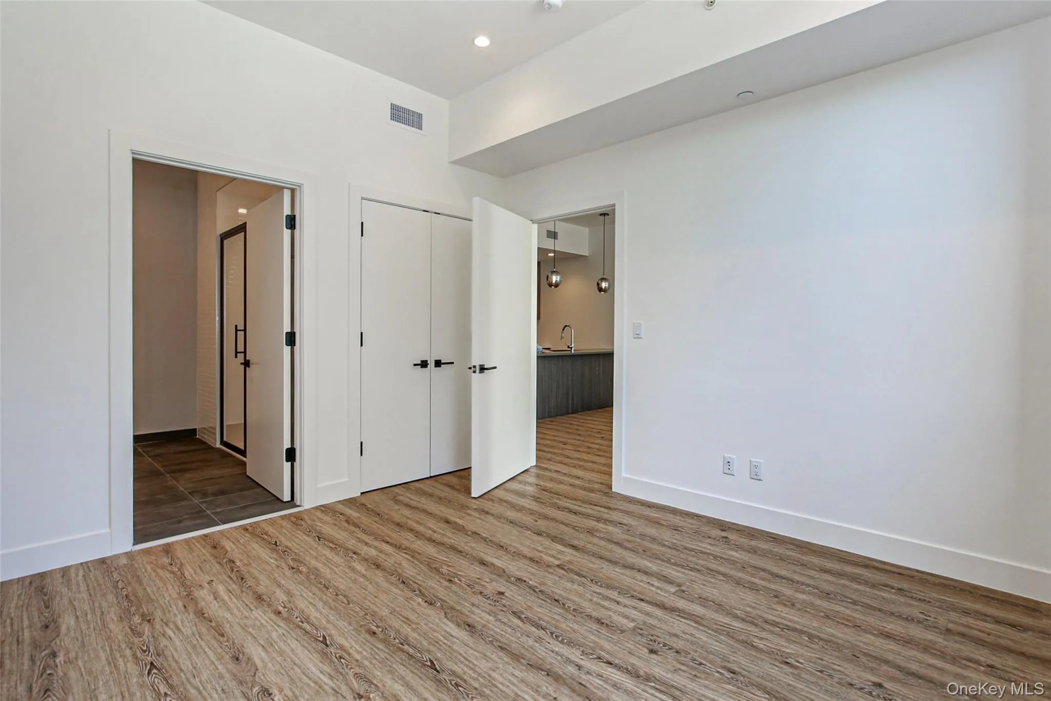 Unfurnished bedroom featuring wood finished floors and recessed lighting Unfurnished bedroom featuring wood finished floors and recessed lighting