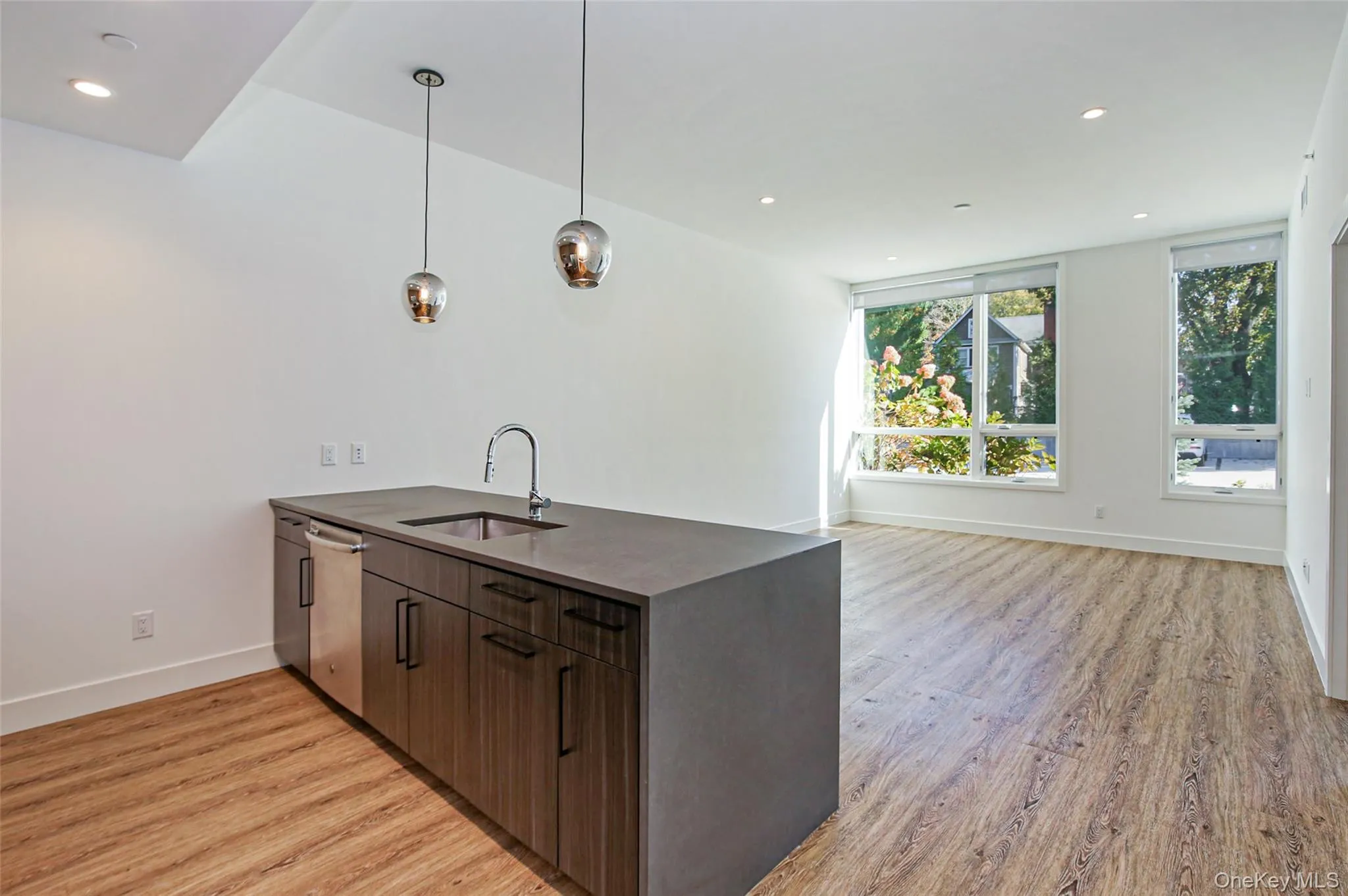 Kitchen featuring a peninsula, light wood-type flooring, recessed lighting, dishwasher, and hanging light fixtures Kitchen featuring a peninsula, light wood-type flooring, recessed lighting, dishwasher, and hanging light fixtures