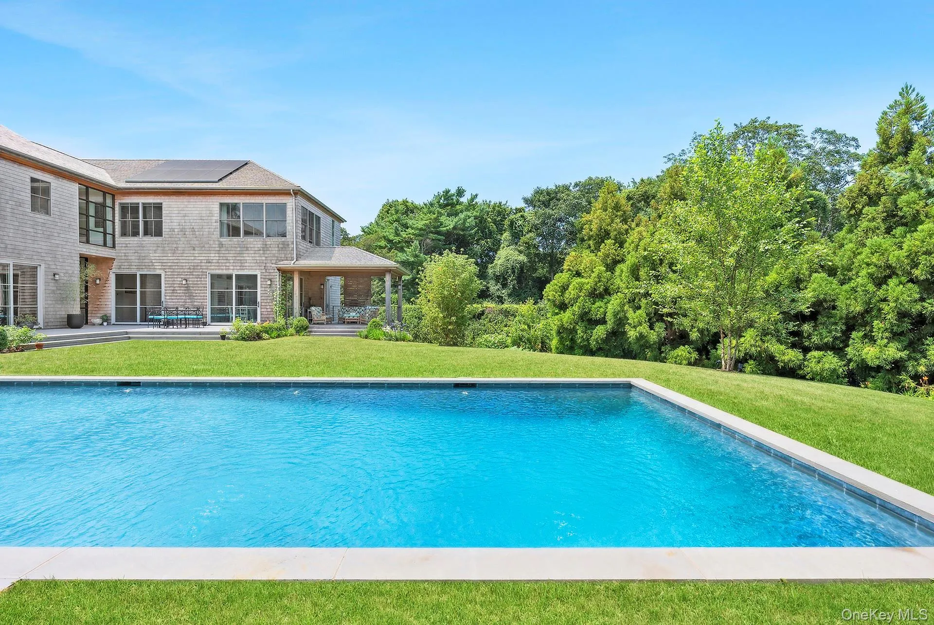 Swimming pool with a patio and a yard Swimming pool with a patio and a yard