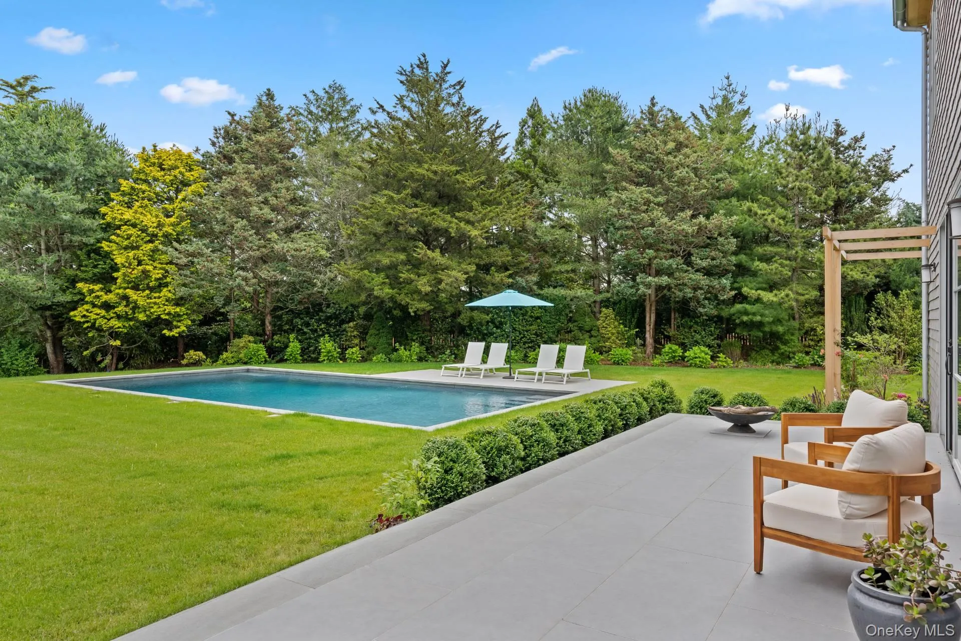 Swimming pool featuring a yard and a patio Swimming pool featuring a yard and a patio
