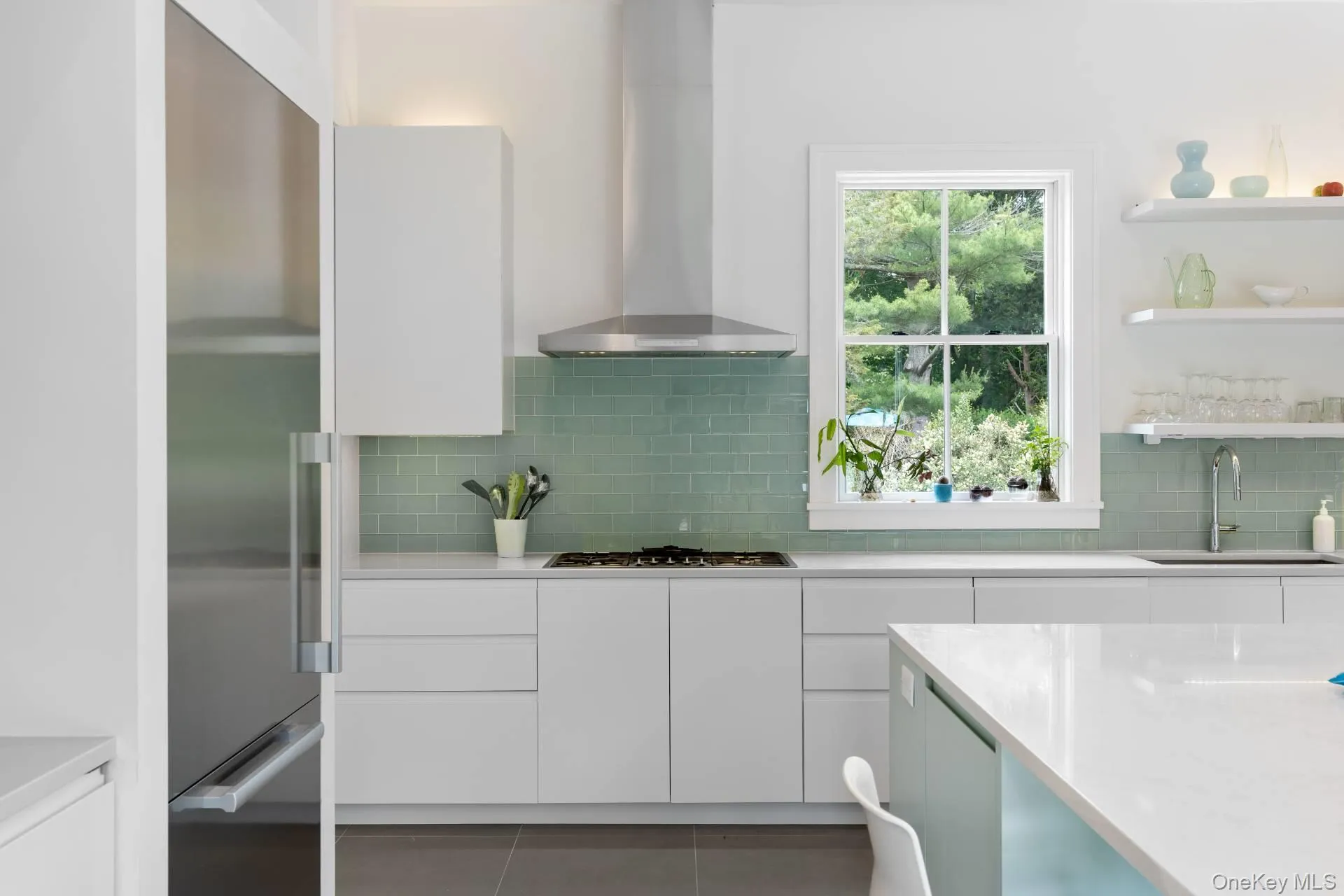 Kitchen featuring modern cabinets, white cabinets, wall chimney exhaust hood, appliances with stainless steel finishes, and open shelves Kitchen featuring modern cabinets, white cabinets, wall chimney exhaust hood, appliances with stainless steel finishes, and open shelves
