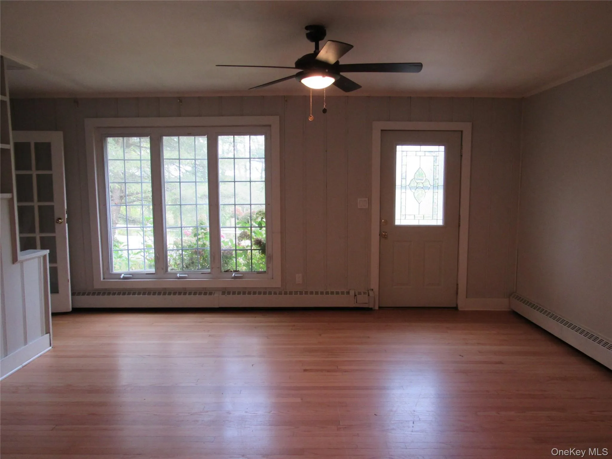 Entryway/Living Rm with light wood finished floors, baseboard heating, and a ceiling fan Entryway/Living Rm with light wood finished floors, baseboard heating, and a ceiling fan