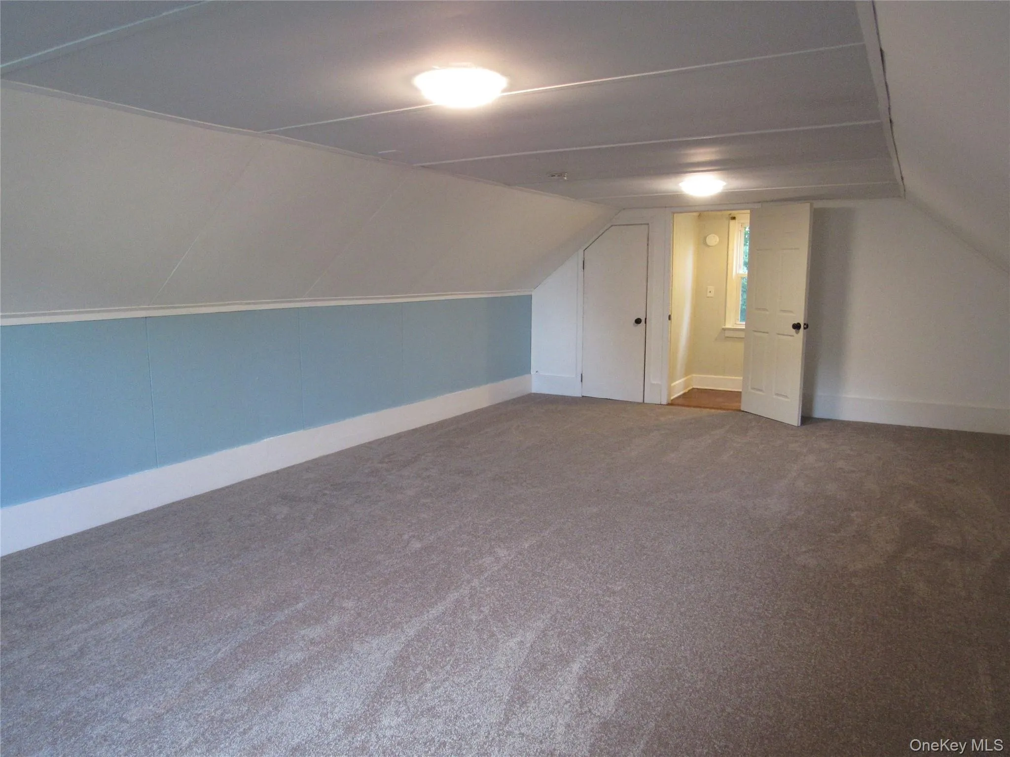 Additional living space with lofted ceiling and dark carpet Additional living space with lofted ceiling and dark carpet