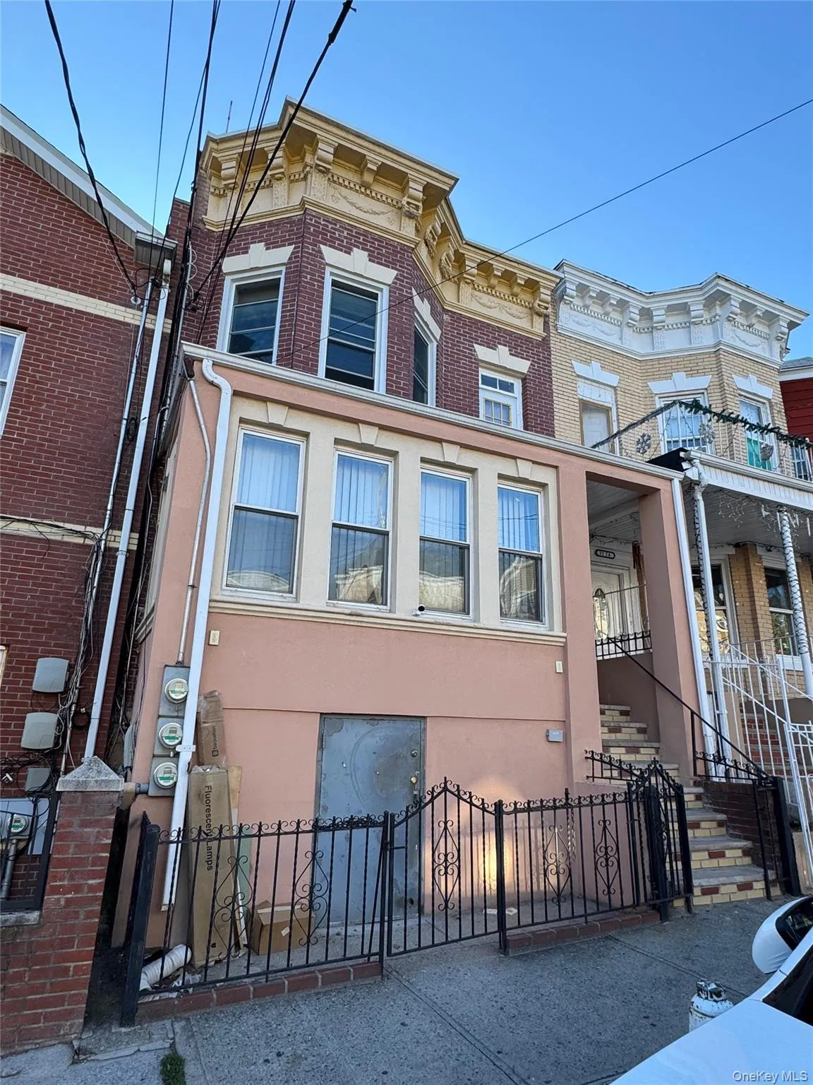 Italianate house with a fenced front yard, stucco siding, brick siding, and a gate Italianate house with a fenced front yard, stucco siding, brick siding, and a gate