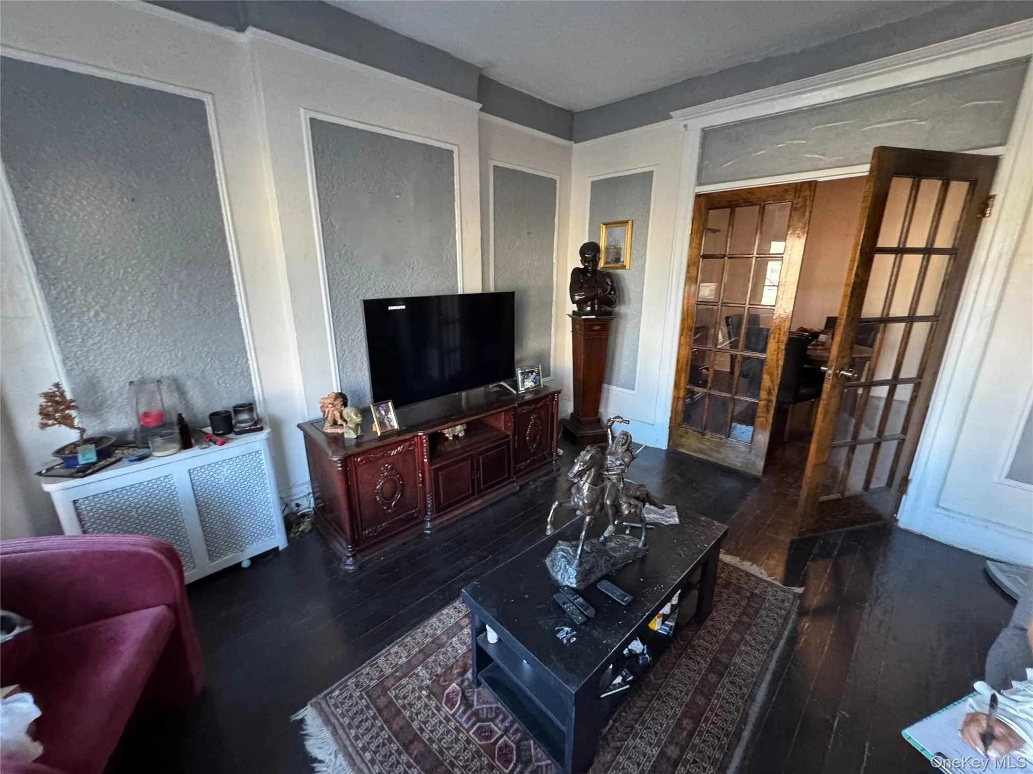 Living room featuring dark wood finished floors and radiator heating unit Living room featuring dark wood finished floors and radiator heating unit