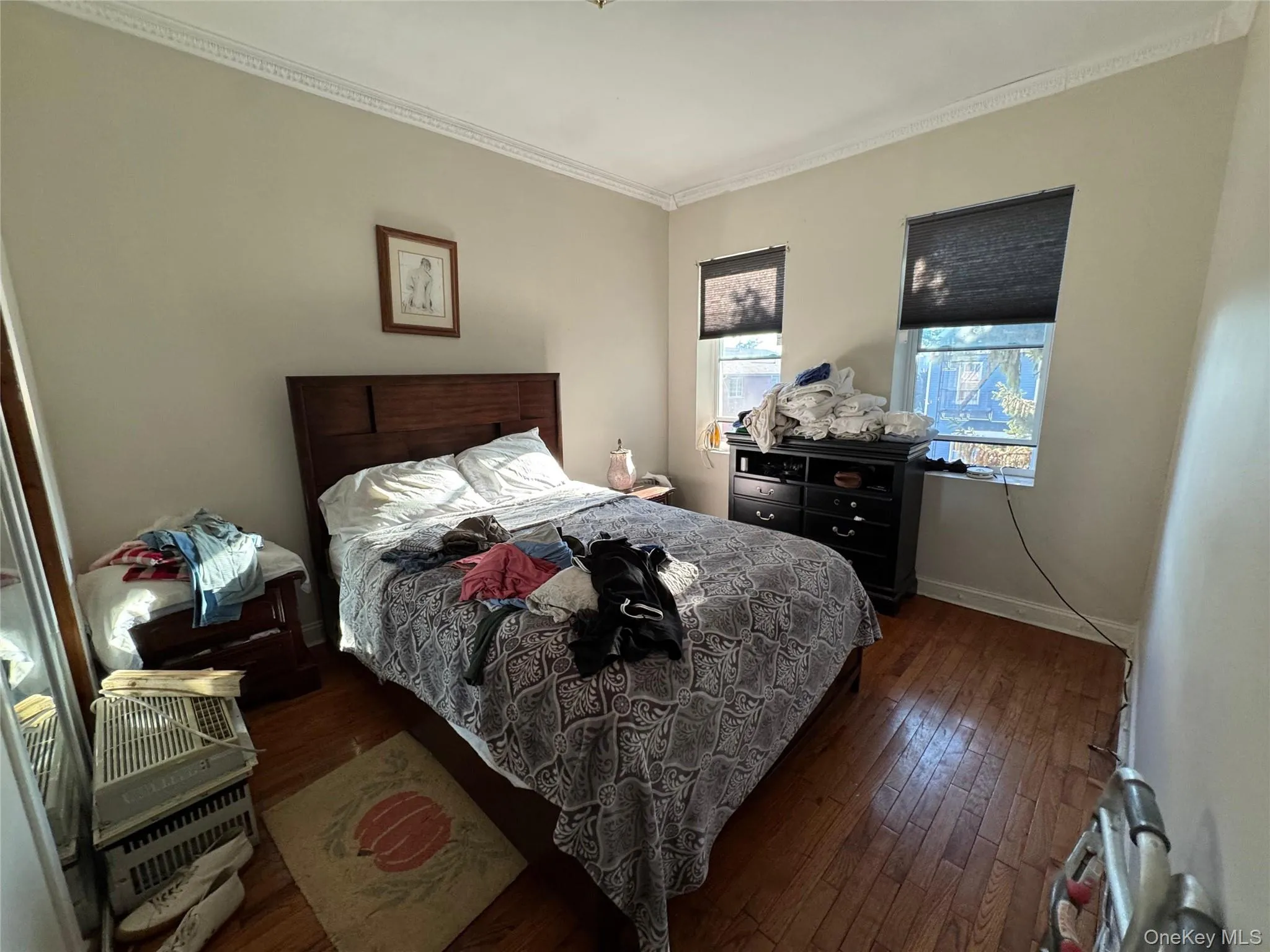 Bedroom with dark wood-style floors and ornamental molding Bedroom with dark wood-style floors and ornamental molding