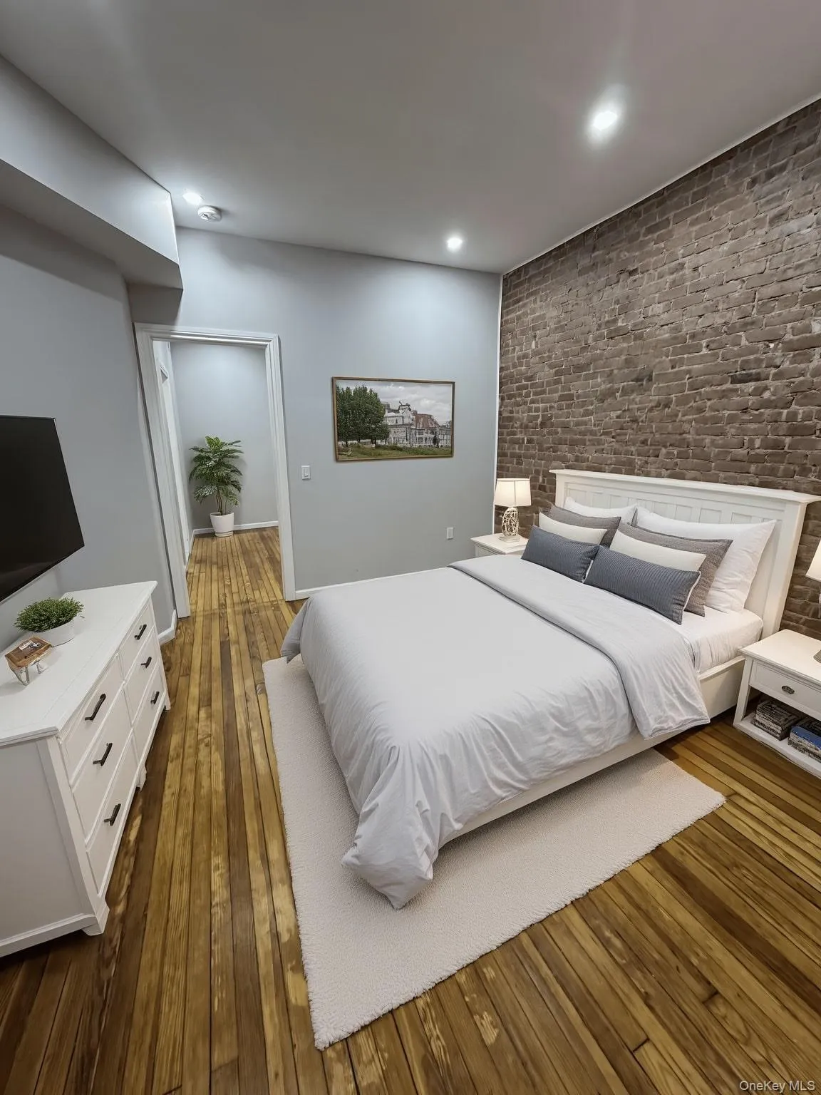 Bedroom with dark wood-style floors, brick wall, recessed lighting, and an accent wall Bedroom with dark wood-style floors, brick wall, recessed lighting, and an accent wall